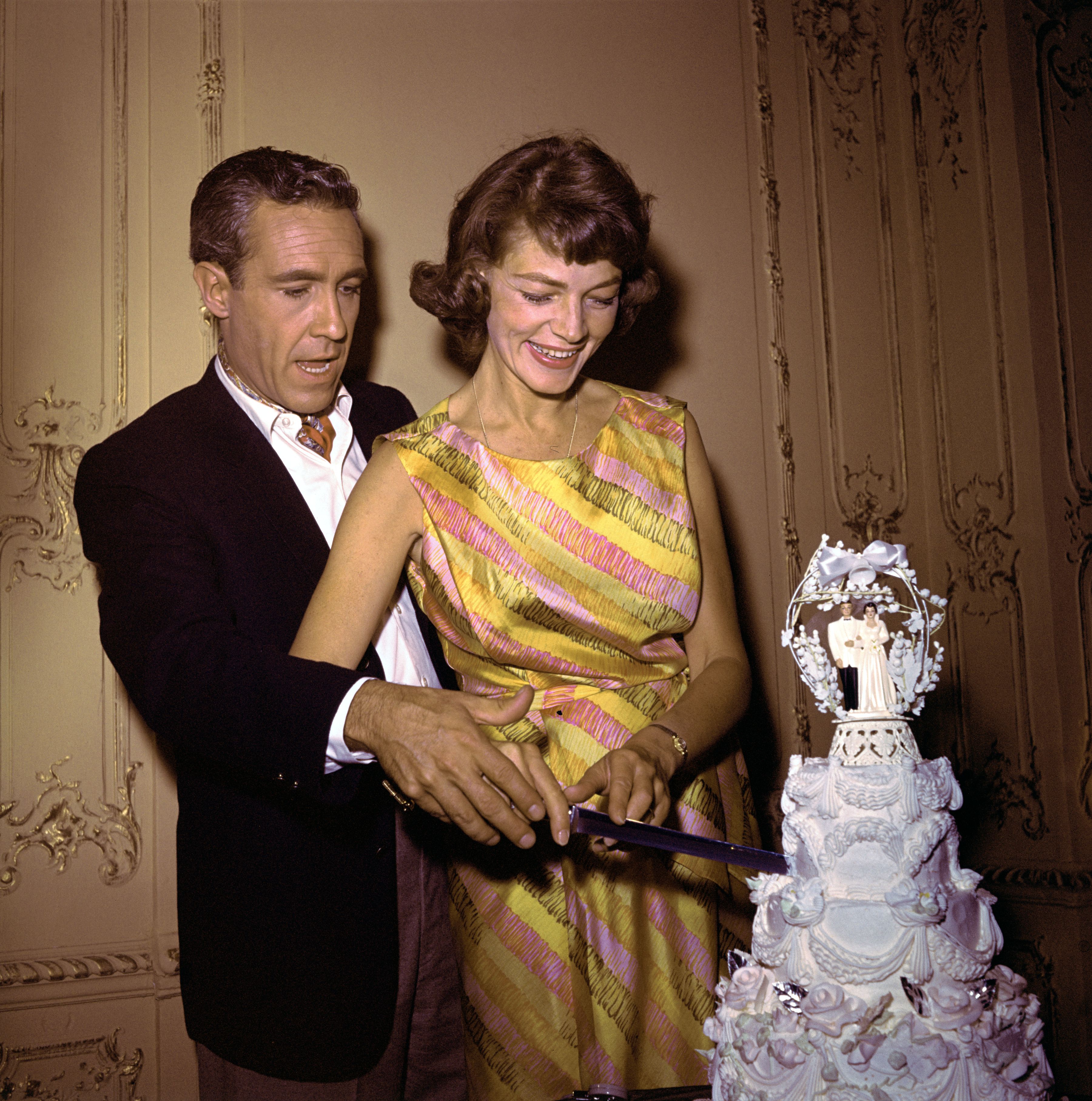 Jason Robards and Lauren Bacall cutting their wedding cake on July 5, 1961. | Source: Bettmann/Getty Images