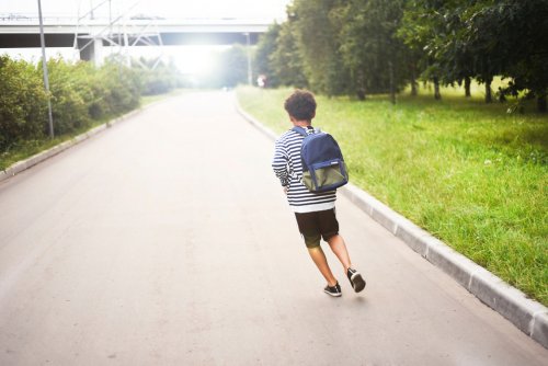 Niño con su bolso de la escuela corriendo por la calle. | Foto: Shutterstock
