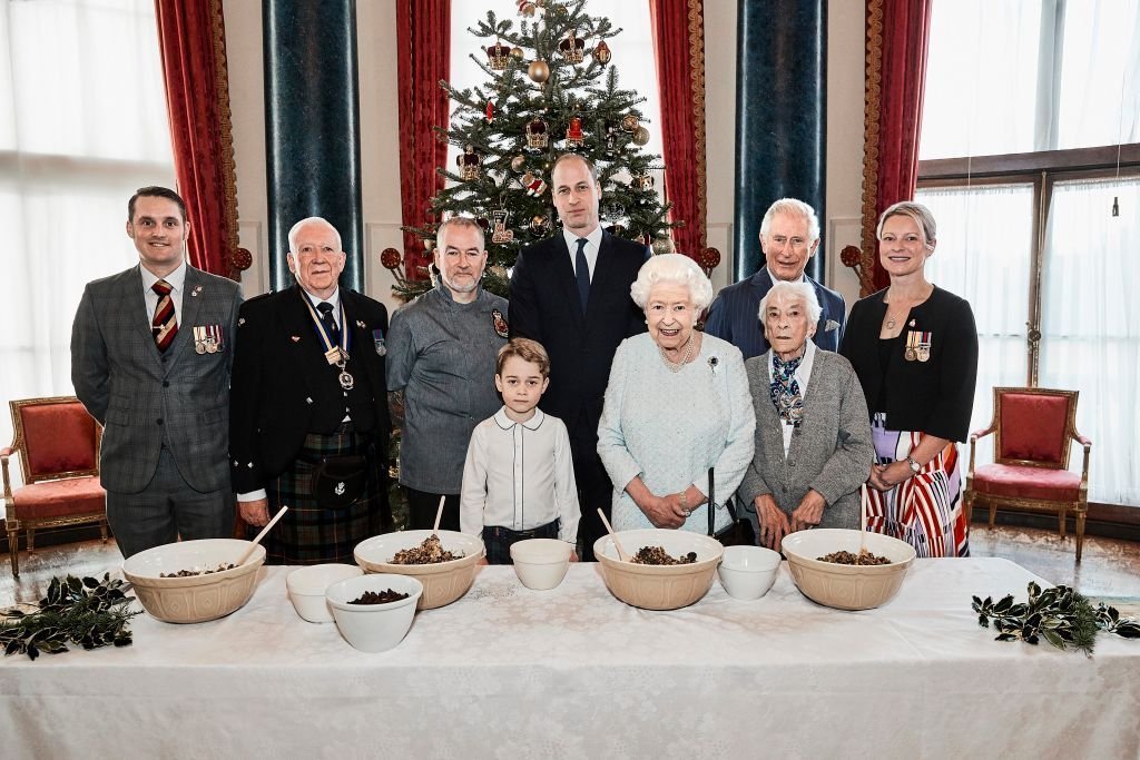 Veterans pose alongside Prince George, Prince William, Duke of Cambridge, Queen Elizabeth II and Prince Charles, Prince of Wales in the Music Room at Buckingham Palace, as part of the launch of The Royal British Legion's Together at Christmas initiative. | Photo: Getty Images