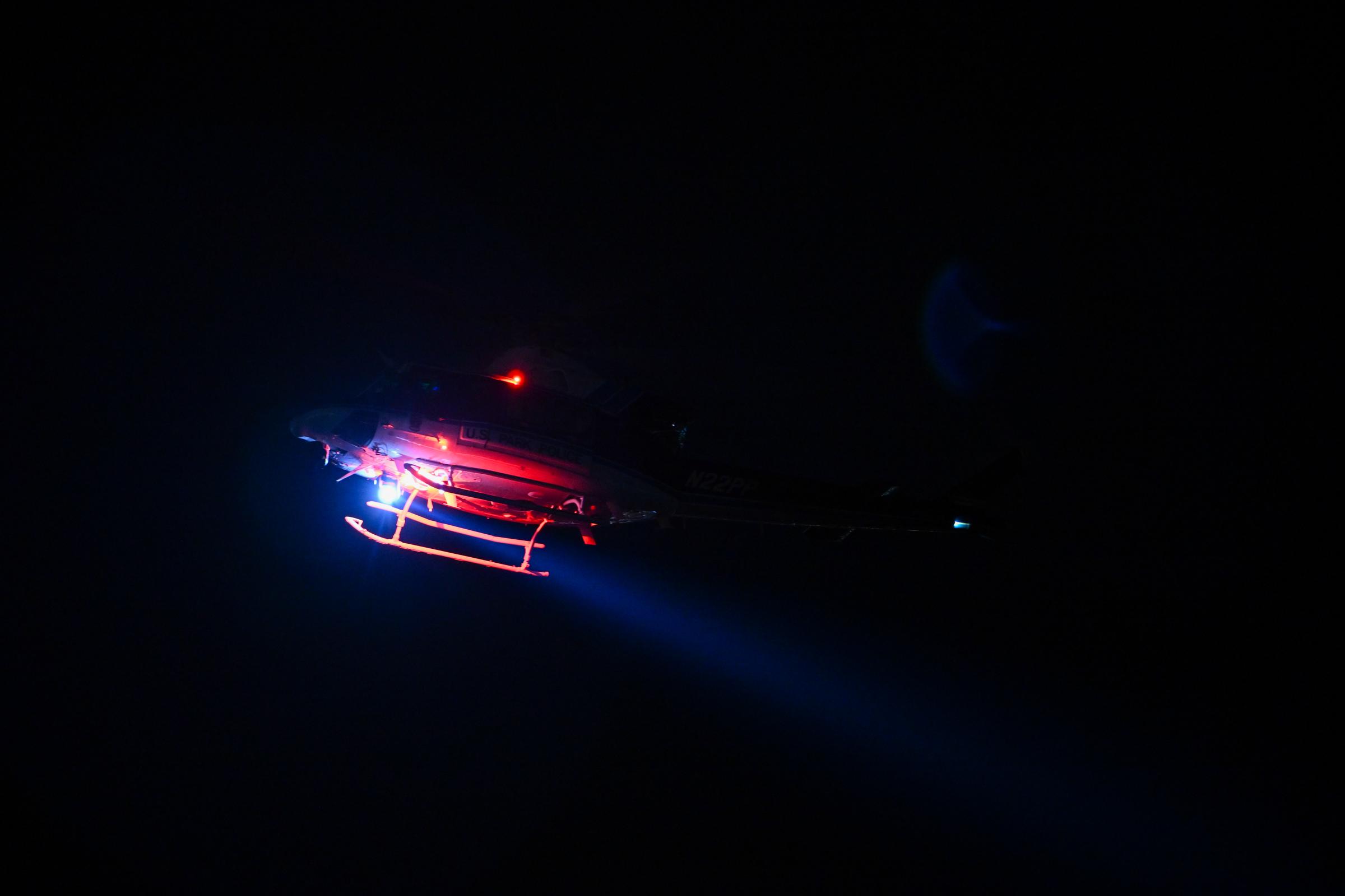 A helicopter flies over the scene area after a regional plane collided in midair with a military helicopter on January 30, 2025, in Washington, D.C. | Source: Getty Images