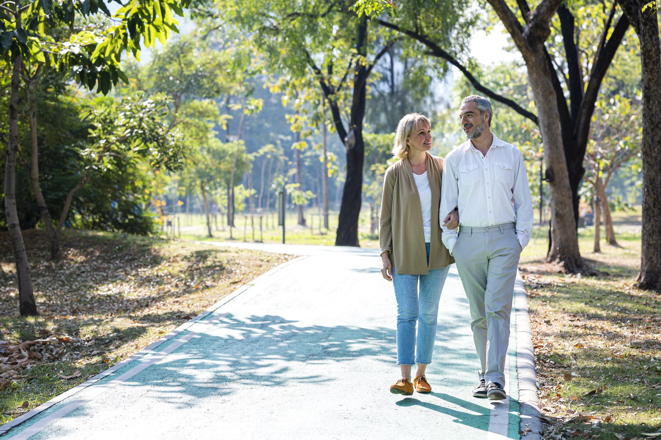 Seniorenpaar, das während des Sommermorgens einen Spaziergang in einem Park unternimmt. I Quelle: Getty Images