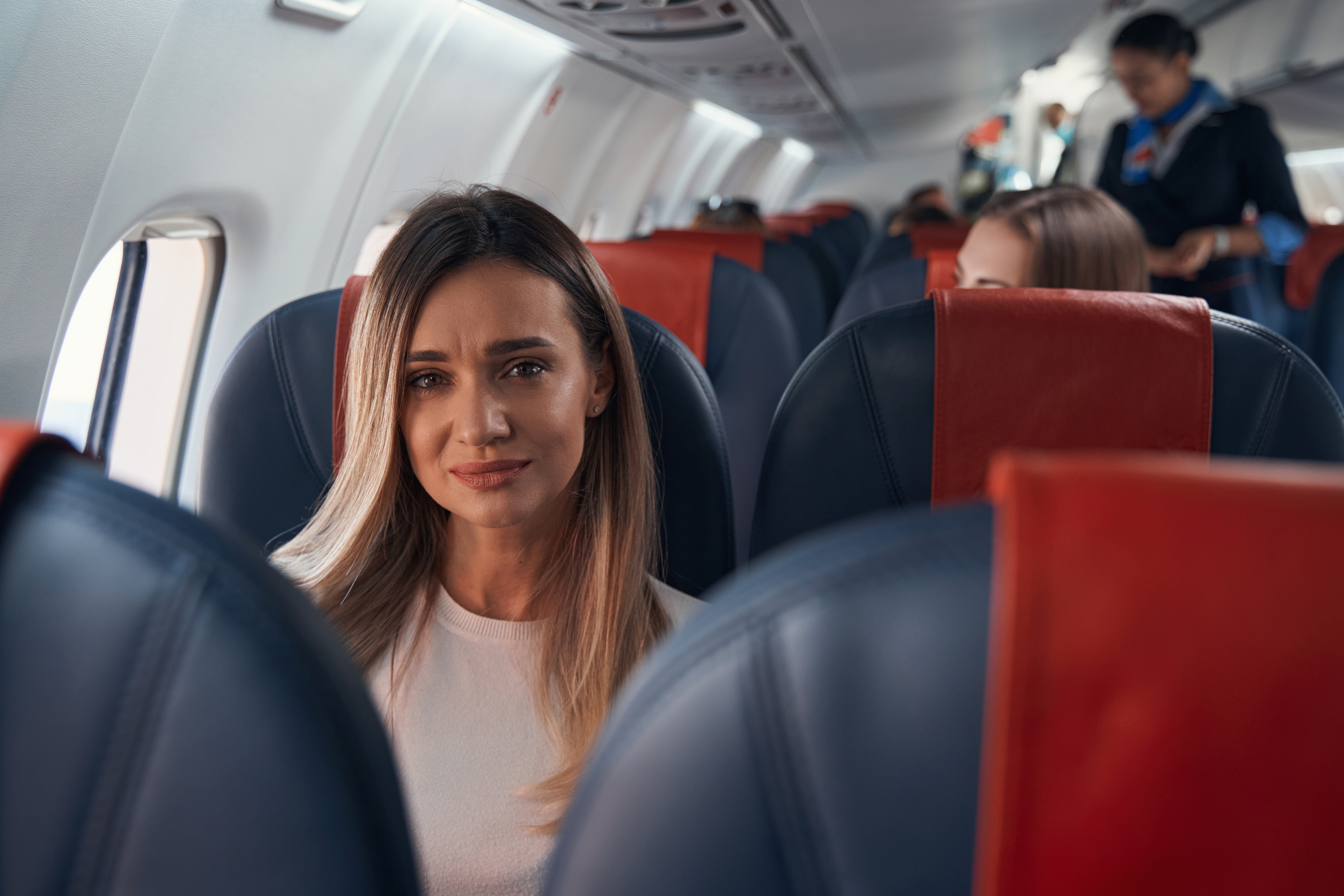 A sad woman in an airplane | Source: Shutterstock