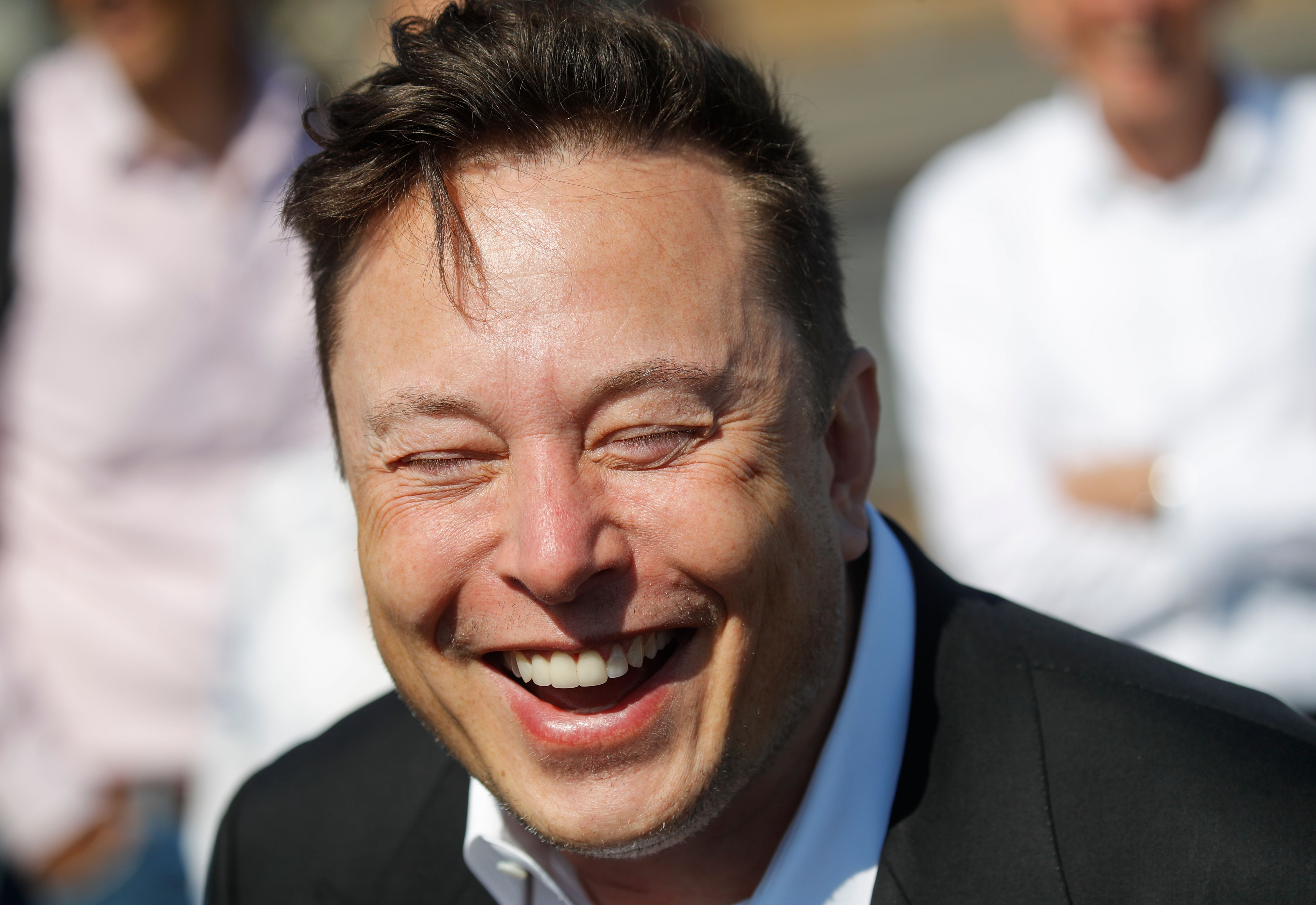Tesla CEO Elon Musk laughs as he talks to media as he arrives to visit the construction site of the future US electric car giant Tesla, on September 03, 2020 in Gruenheide near Berlin. | Source: Getty Images