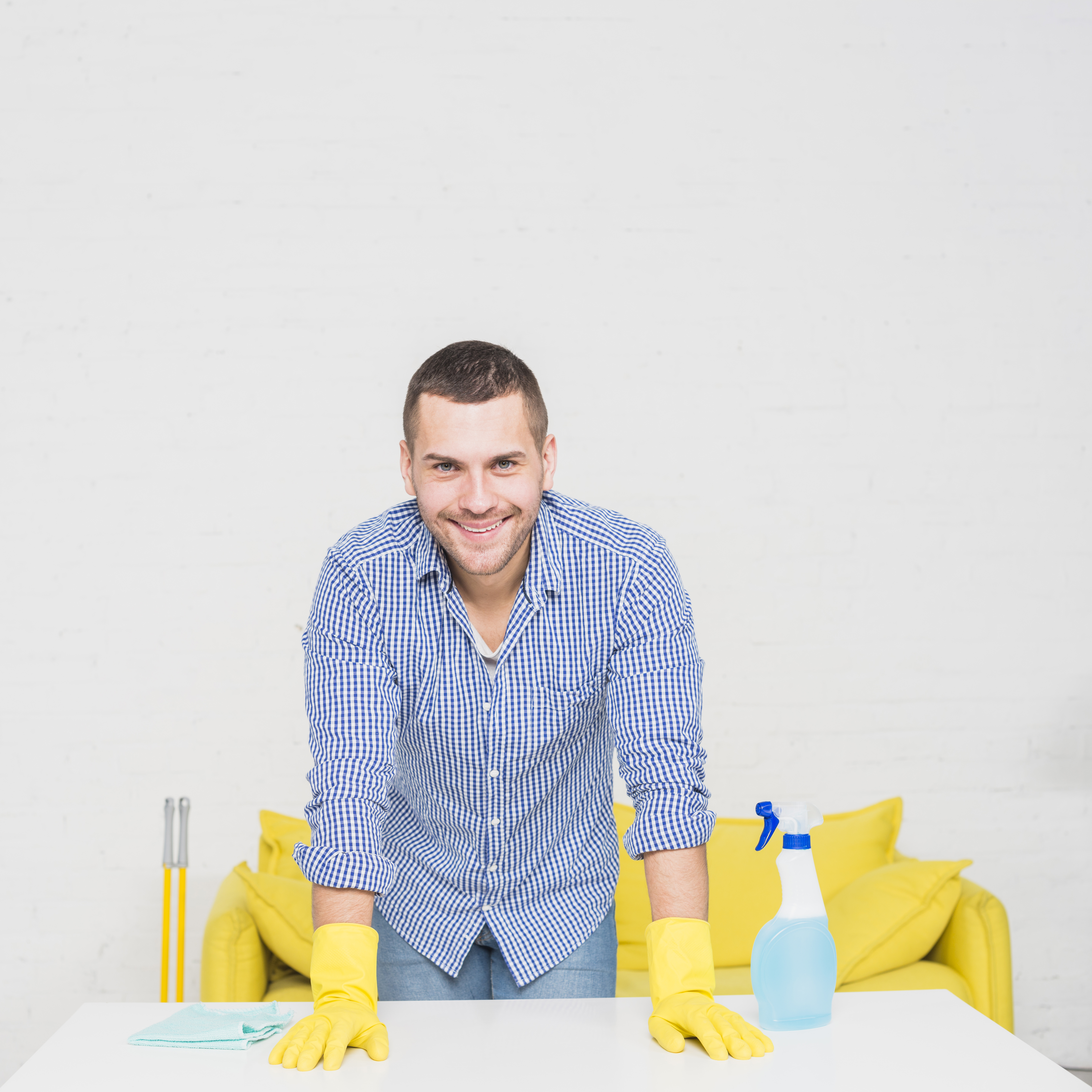 Man smiling as he's surrounded by cleaning materials | Source: Freepik