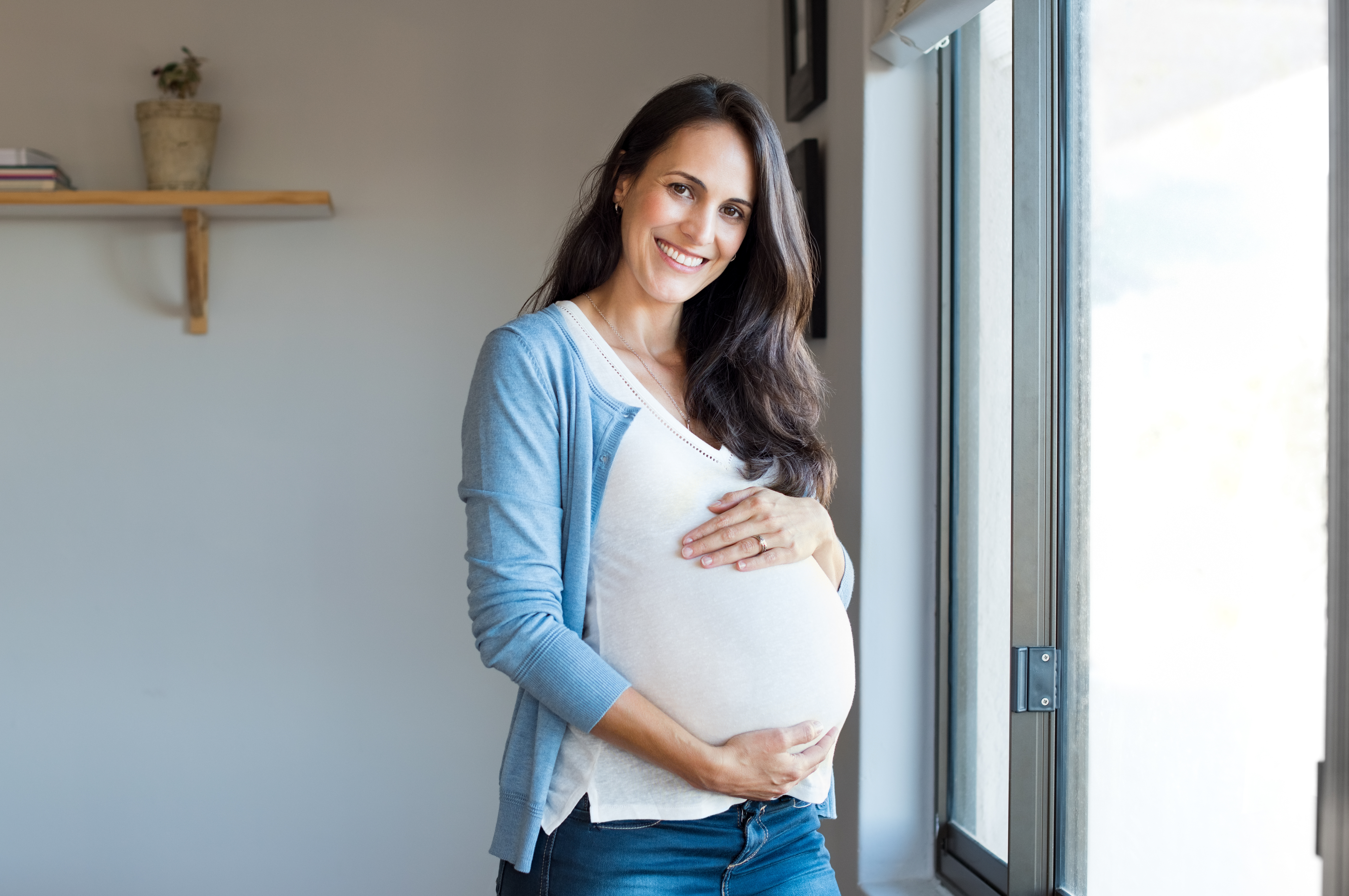 Happy pregnant woman holding her baby bump | Source: Shutterstock