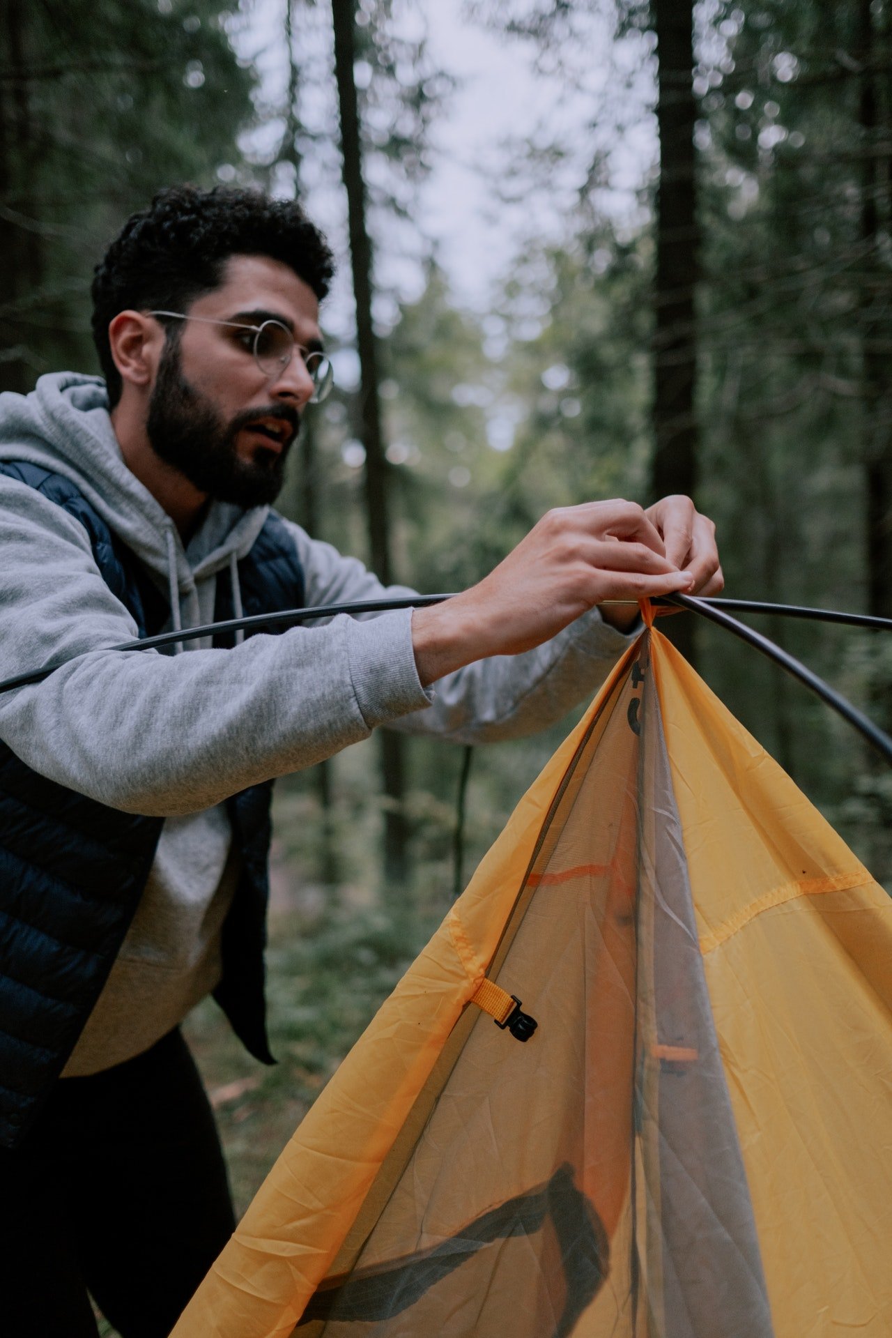 Photo of a man setting up a tent | Photo: Pexels