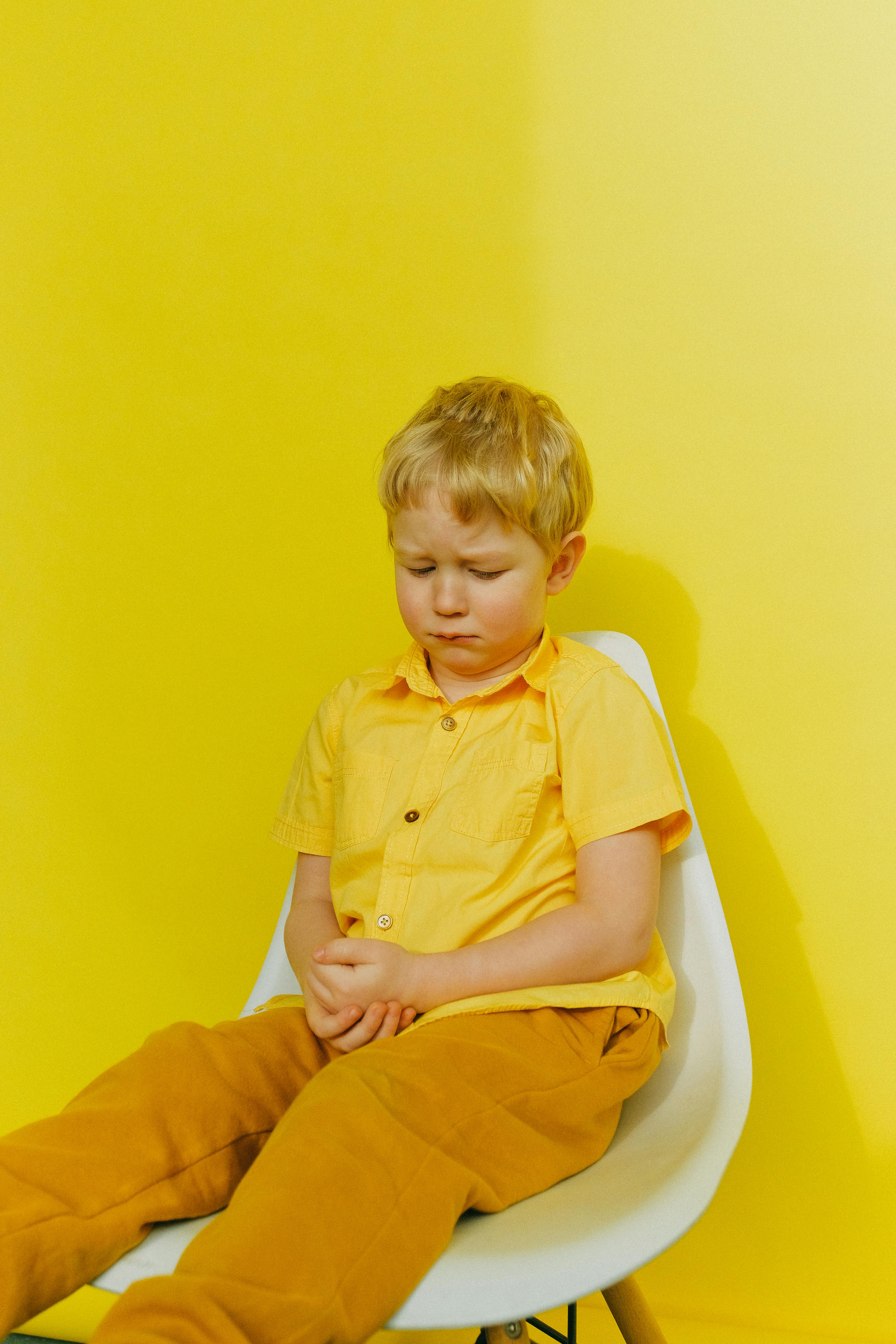 A sad boy sitting on a chair | Source: Pexels