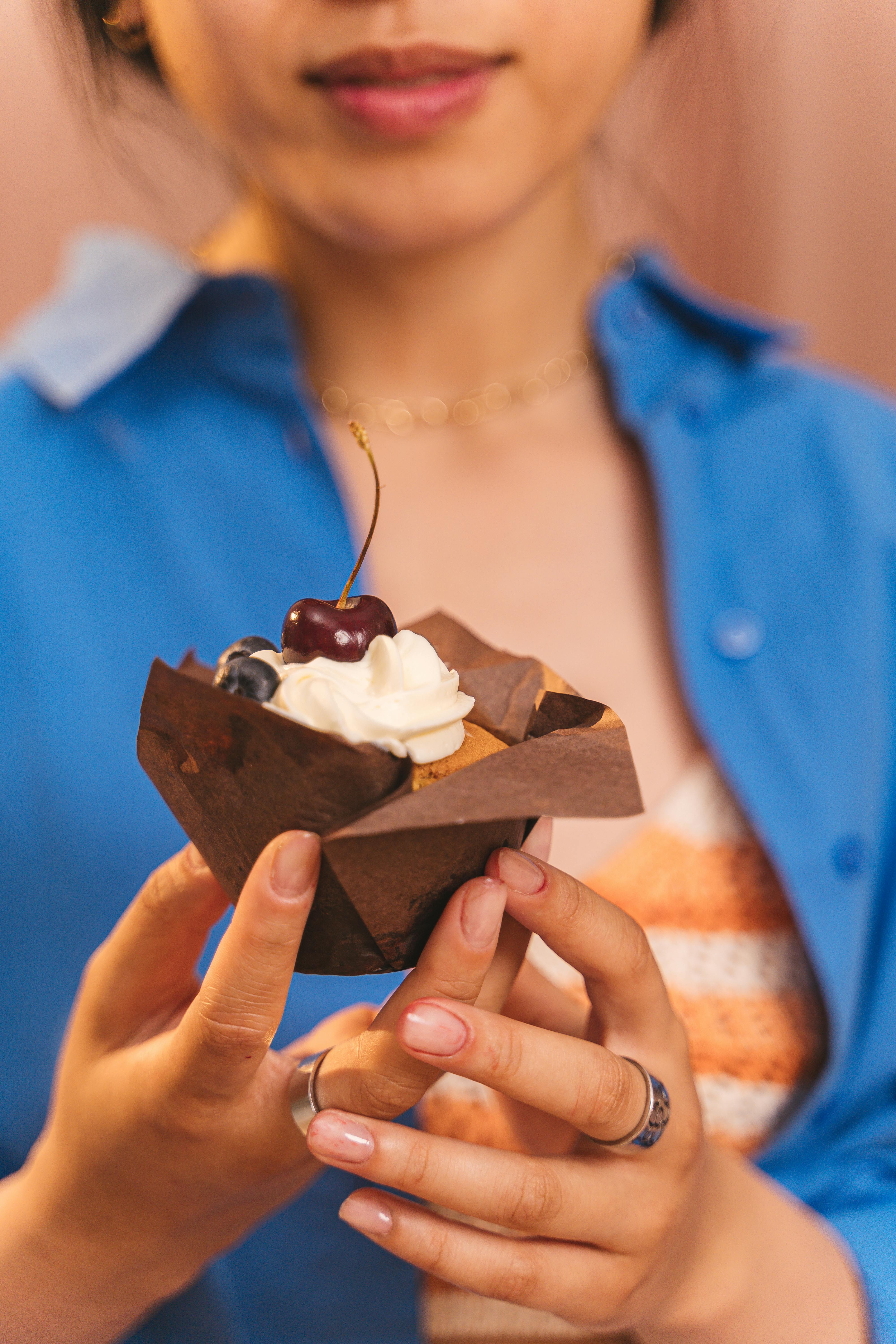 A woman holding a cupcake | Source: Pexels