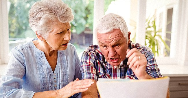 An elderly couple looking at a document. | Source: Shutterstock