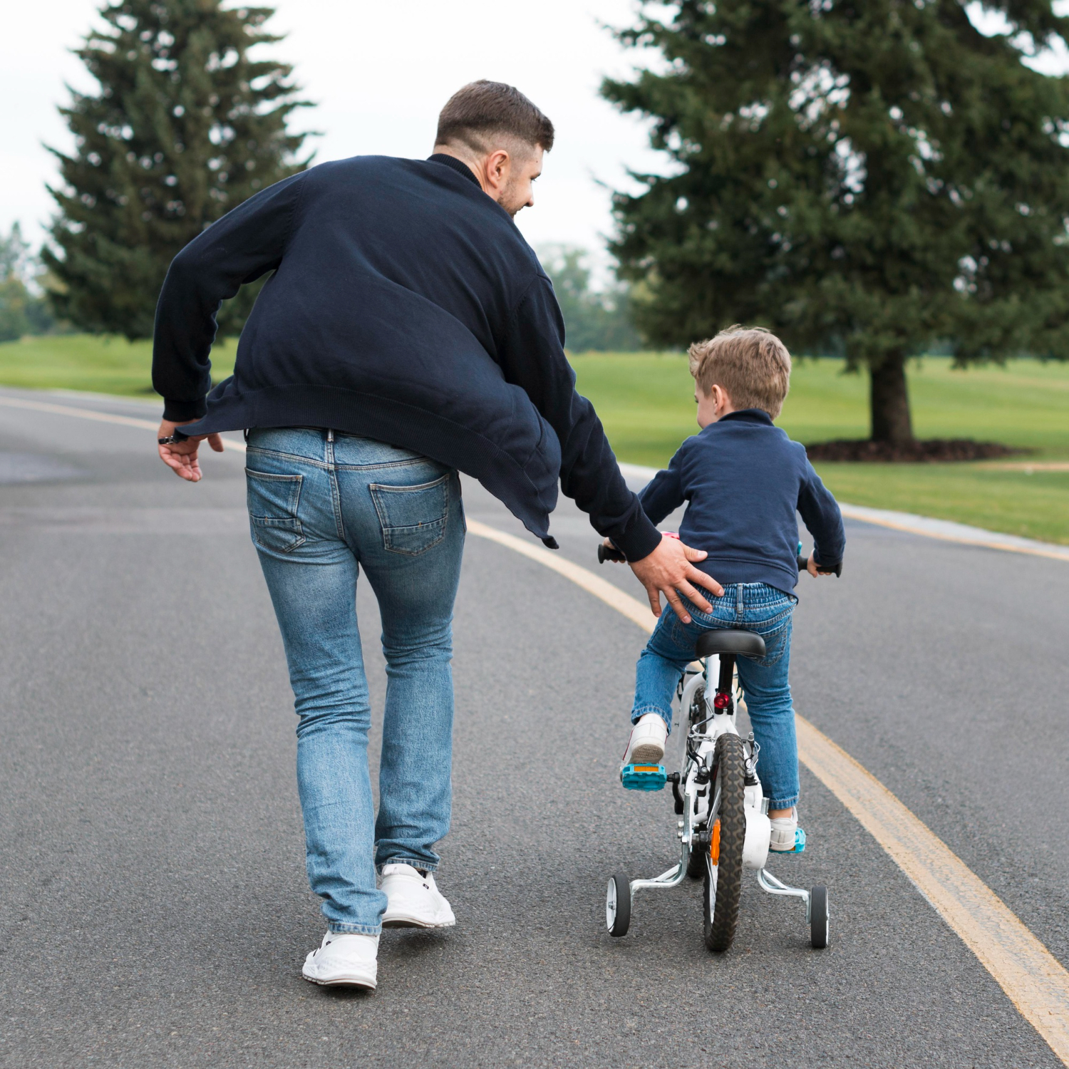 A father teaching his son to ride a bike | Source: Freepik