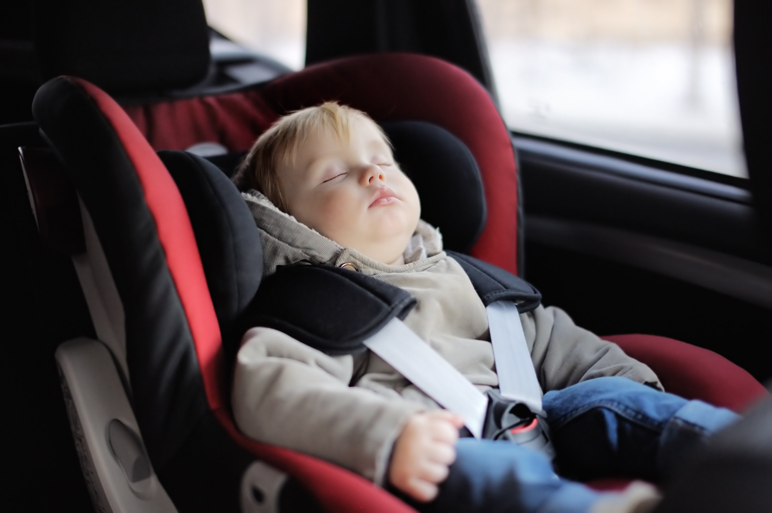 Little boy sleeping inside a car | Photo: Shutterstock