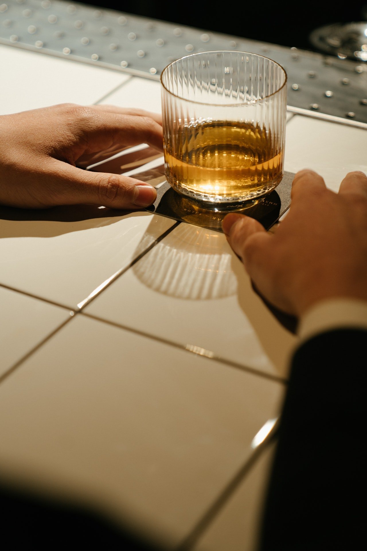 Una persona frente a un vaso con alguna bebida. | Foto: Pexels