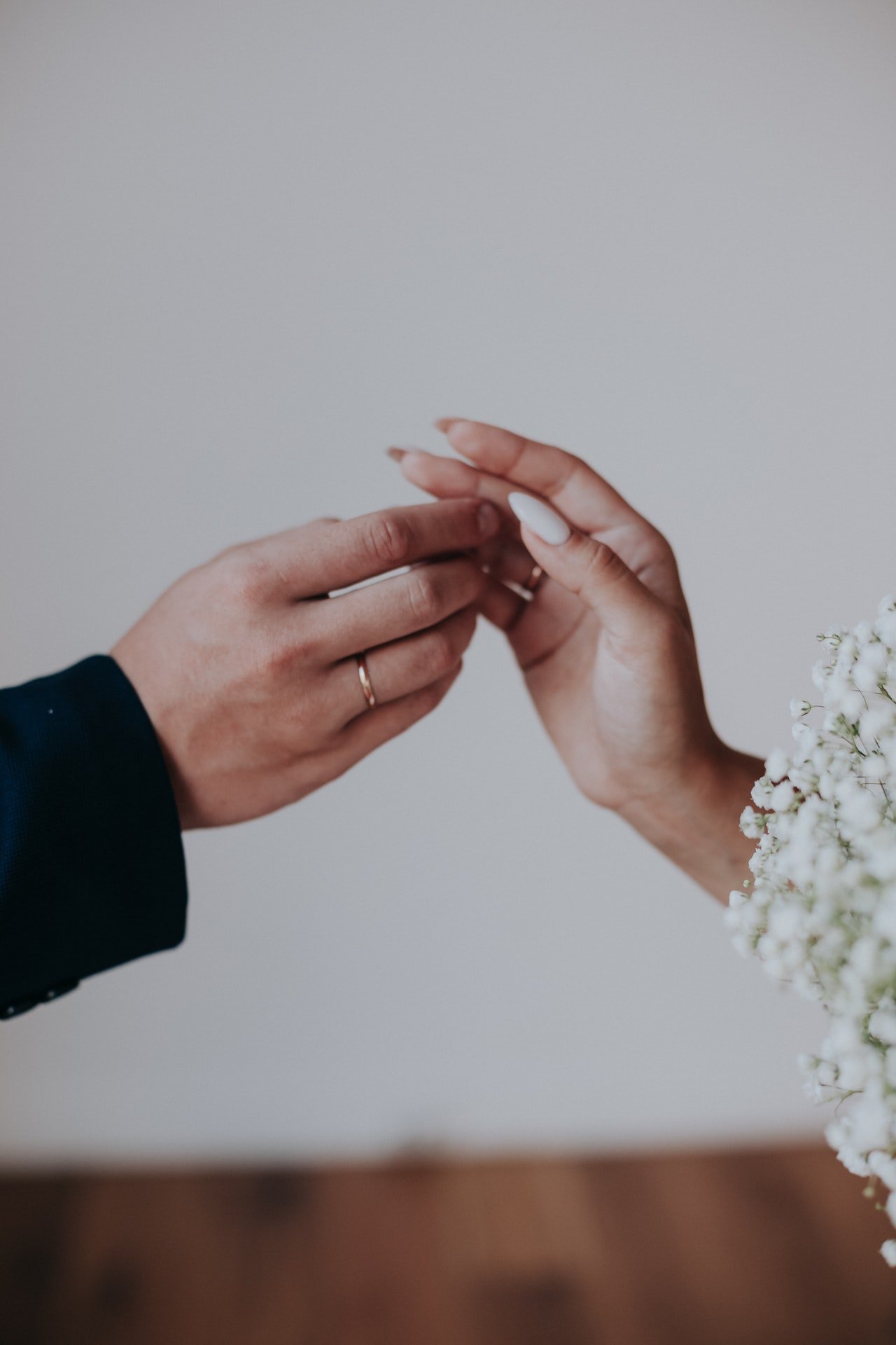 Manos de un hombre y una mujer con anillos de matrimonio. | Foto: Pexels