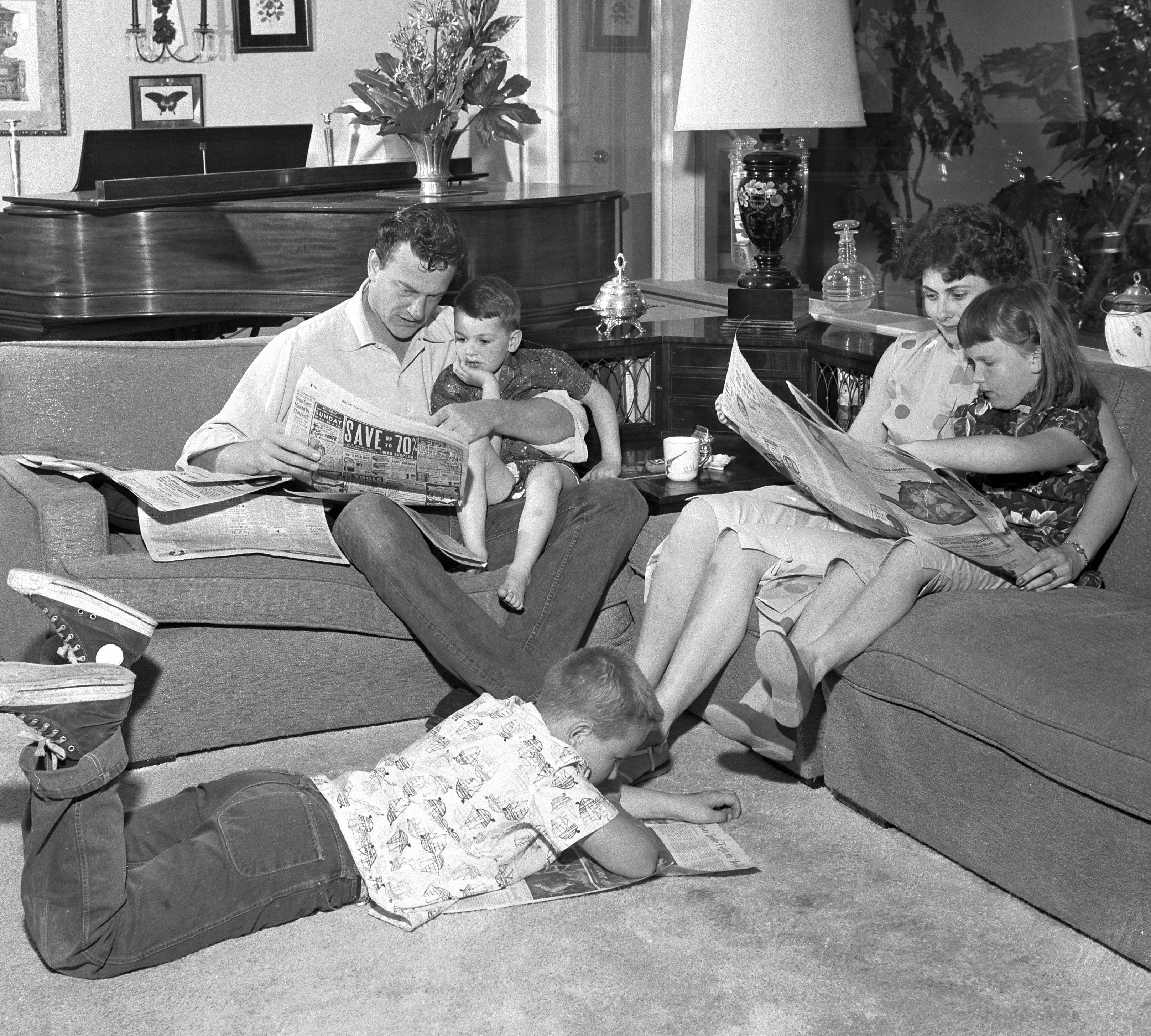 The Arness family at home. James Arness with Rolf (age 5), Virginia with daughter Jenny Lee (age 8) and Craig (age 10) on the floor on May 4, 1957. | Source: Getty Images