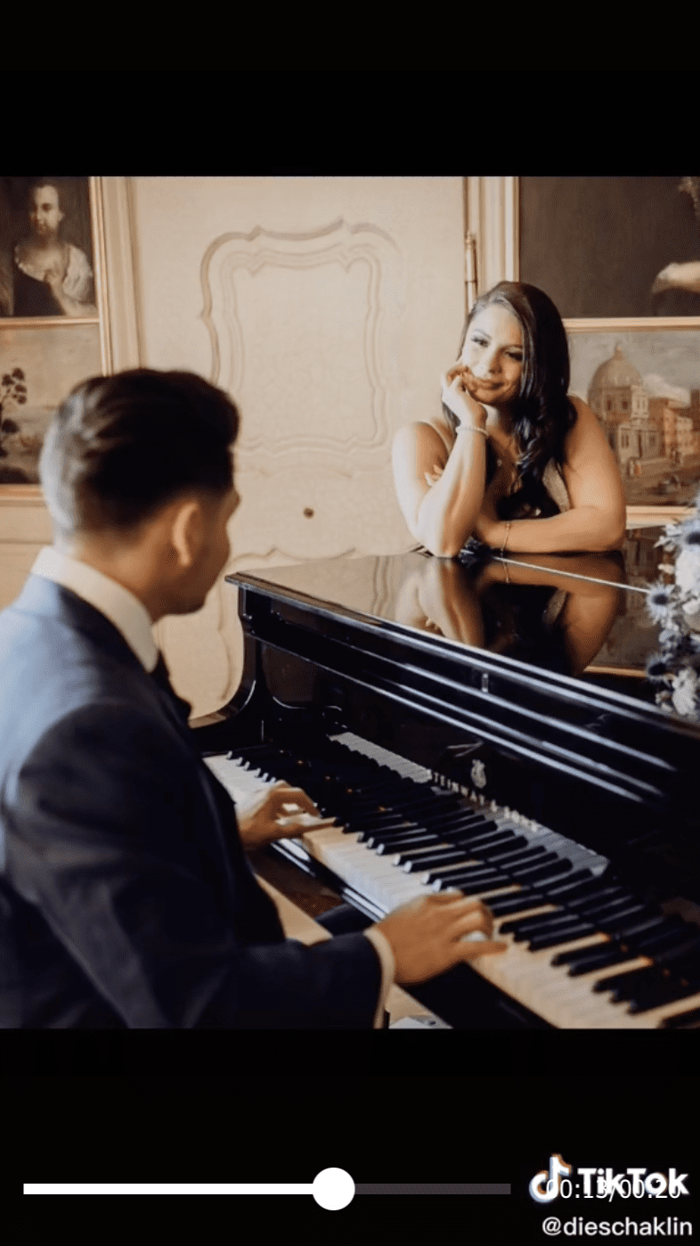 The groom serenading the bride on the piano as she lovingly looks at him. | Photo: tiktok.com/dieschaklin