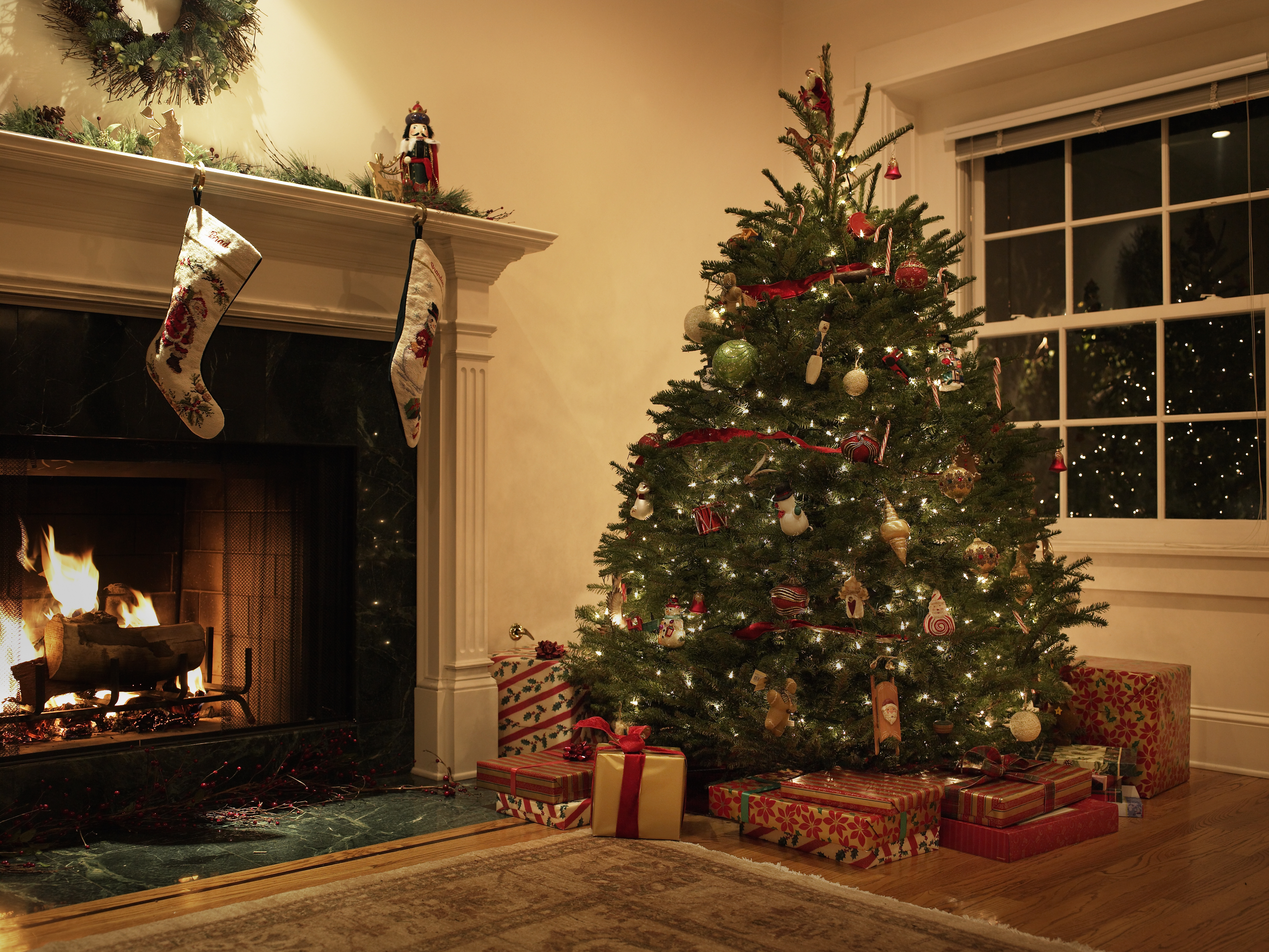 A living room decorated with a Christmas tree and stockings on the fireplace | Source: Getty Images
