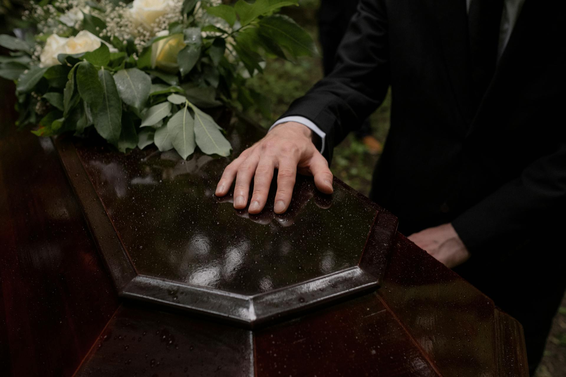 A man's hand on a casket | Source: Pexels