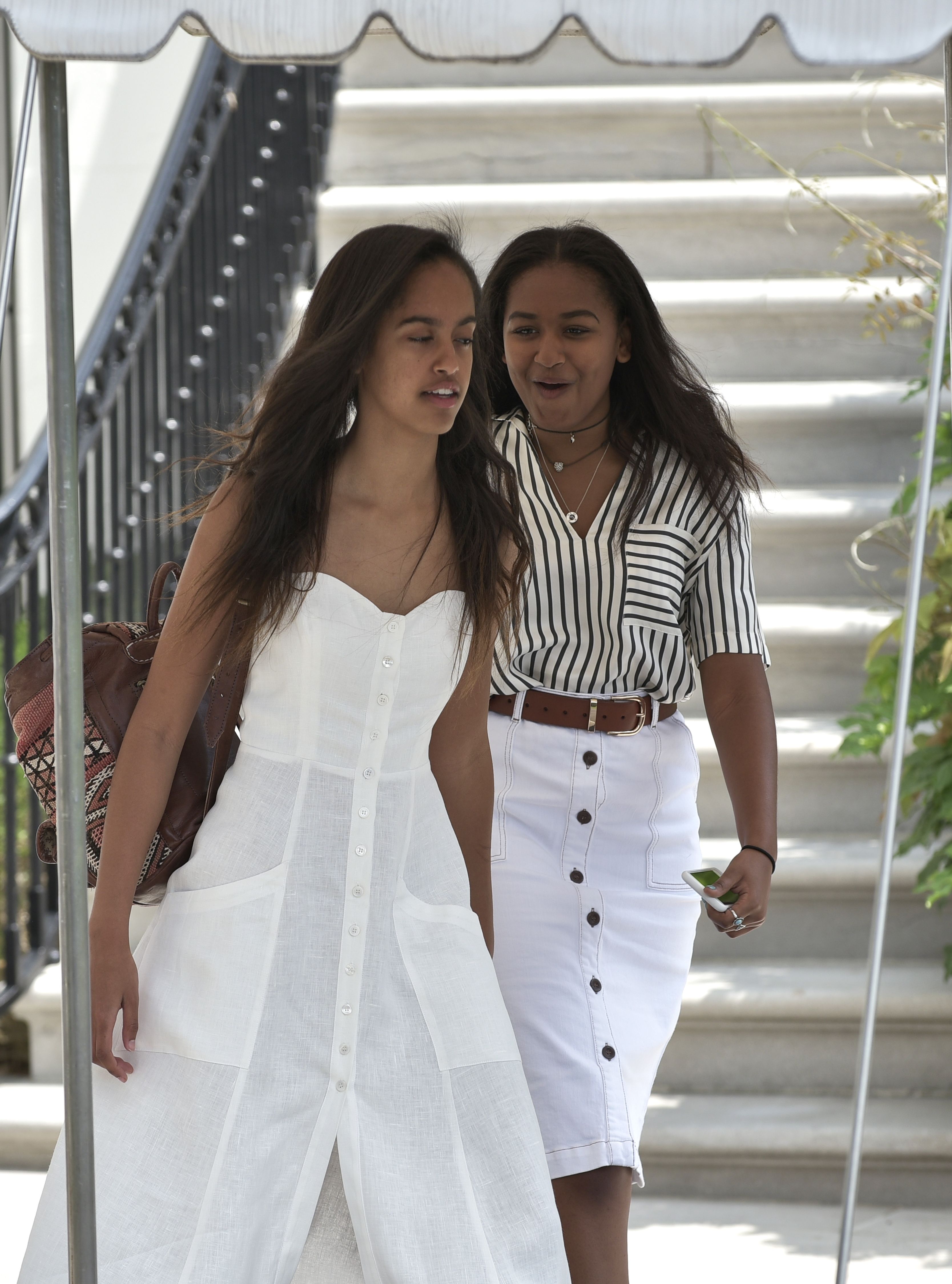 Malia and Sasha, the daughters of US President Barack Obama and First Lady Michelle Obama, make their way to board Marine One ahead of their parents on the South Lawn of the White House in Washington, DC, on August 6, 2016. | Source: Getty Images