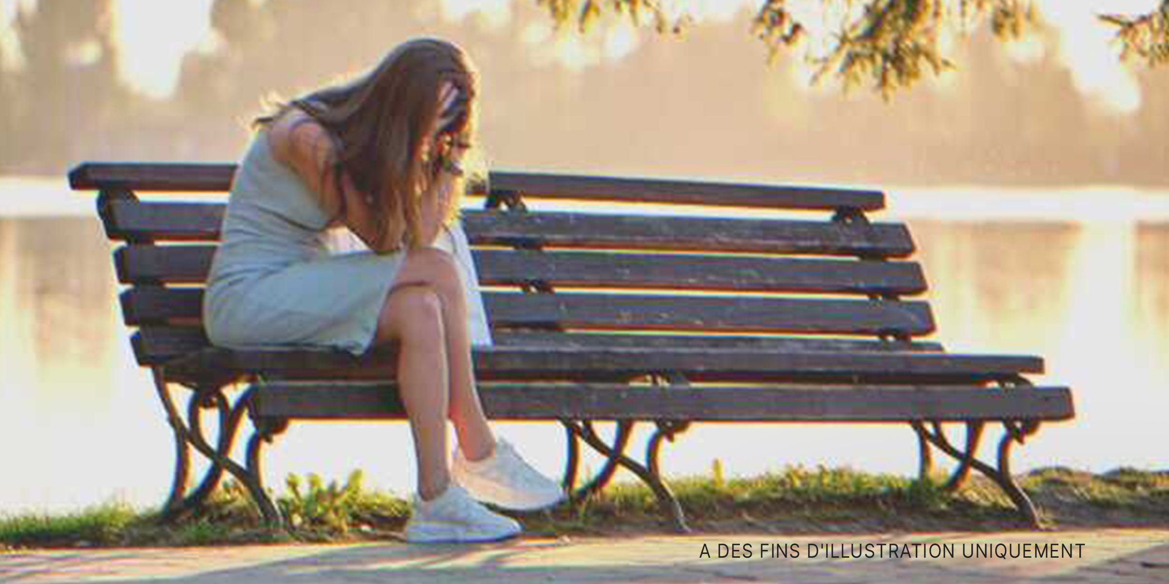 Une femme pleurant sur un banc public | Source : Shutterstock