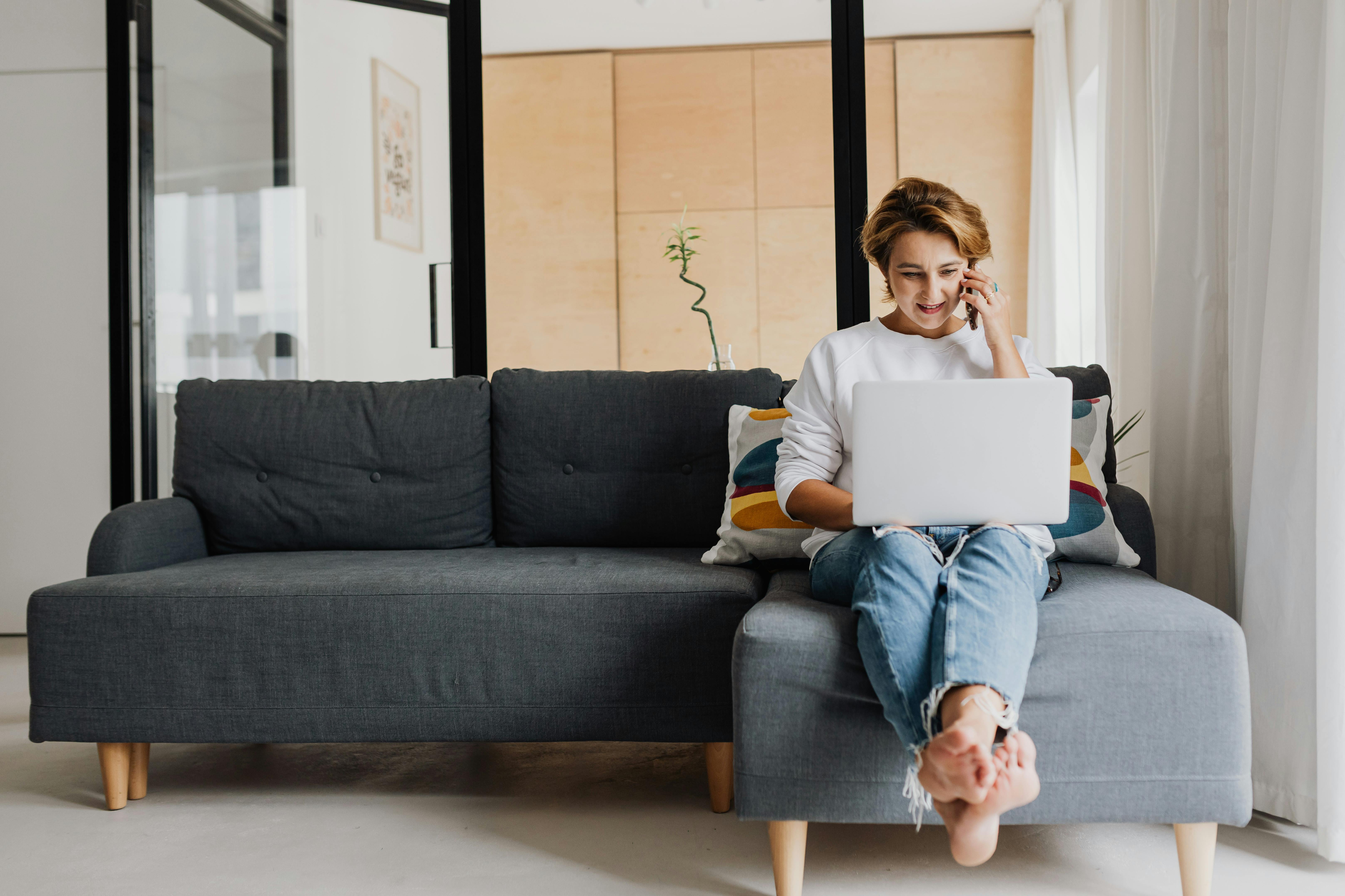 A woman using her laptop and her phone at the same time | Source: Pexels