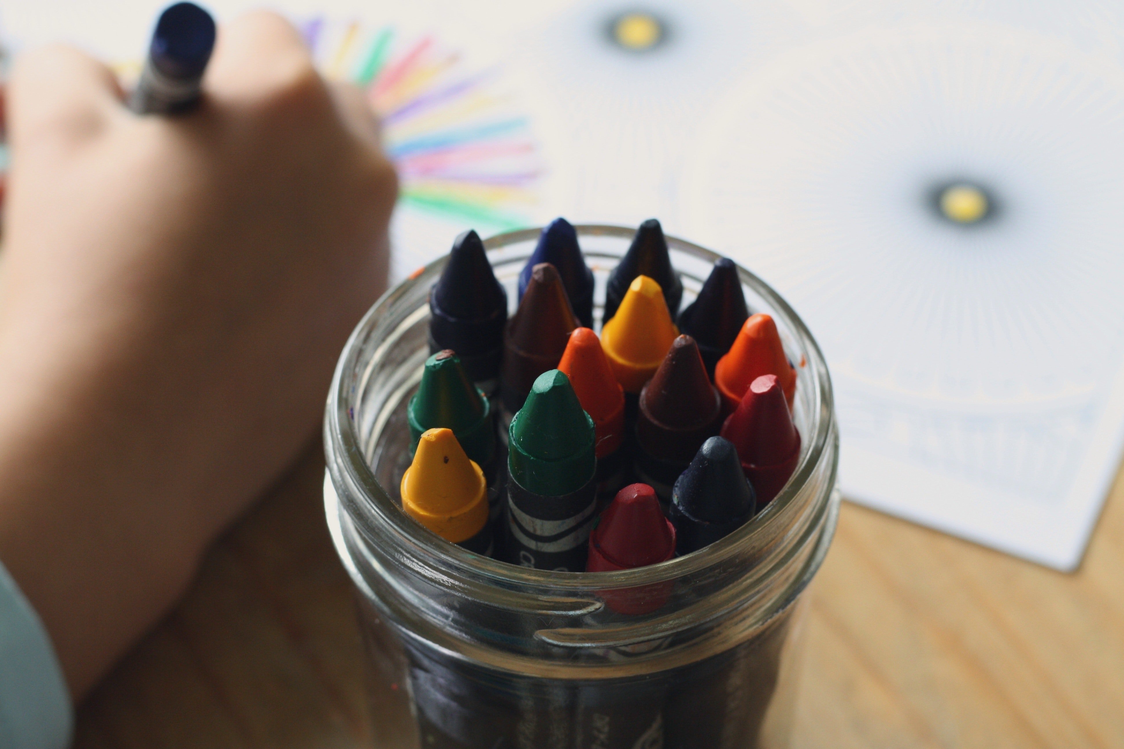 Child drawing with crayons. | Source: Pexels