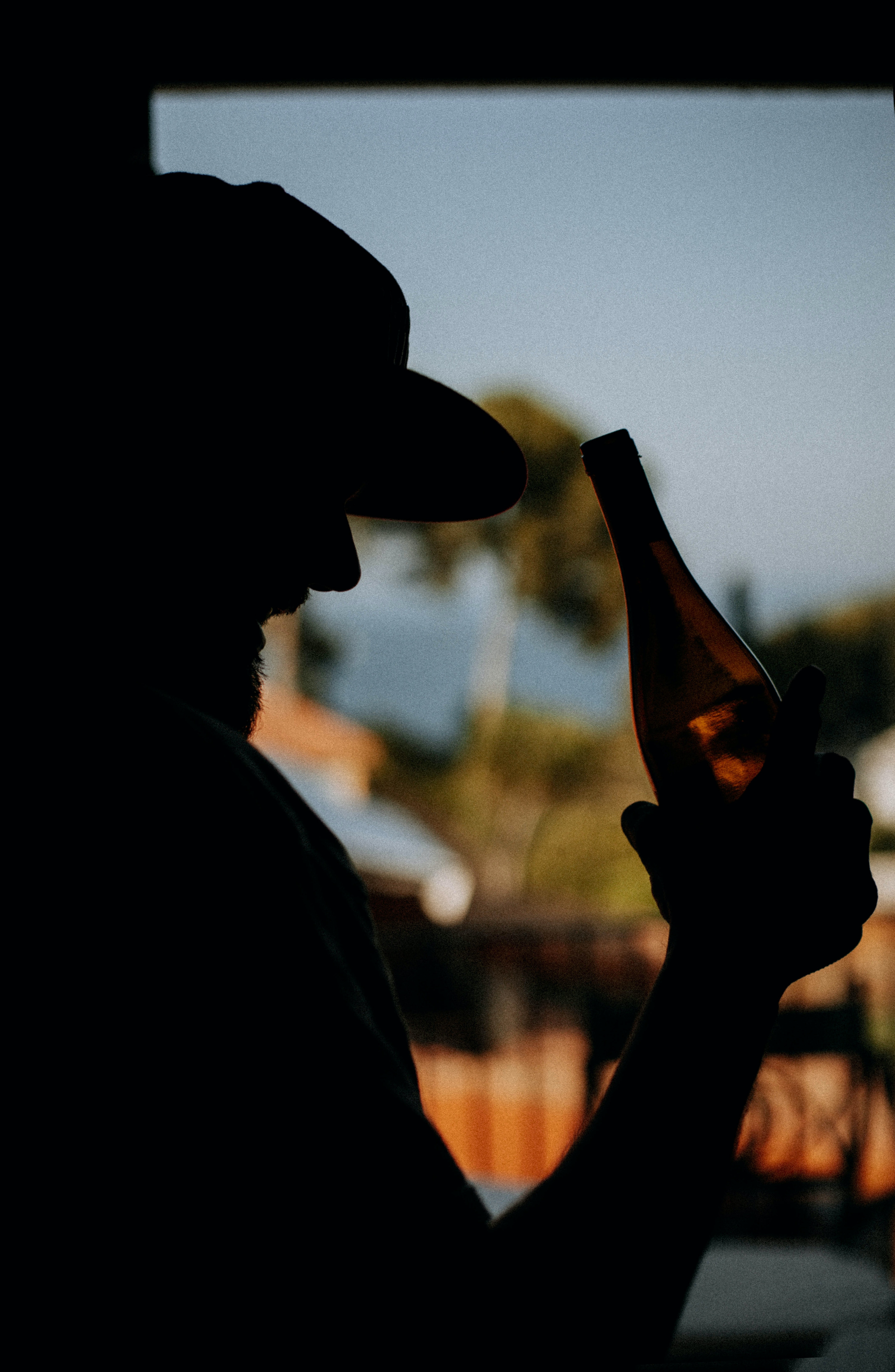 Silhouette of a person holding a bottle of beer | Source: Pexels