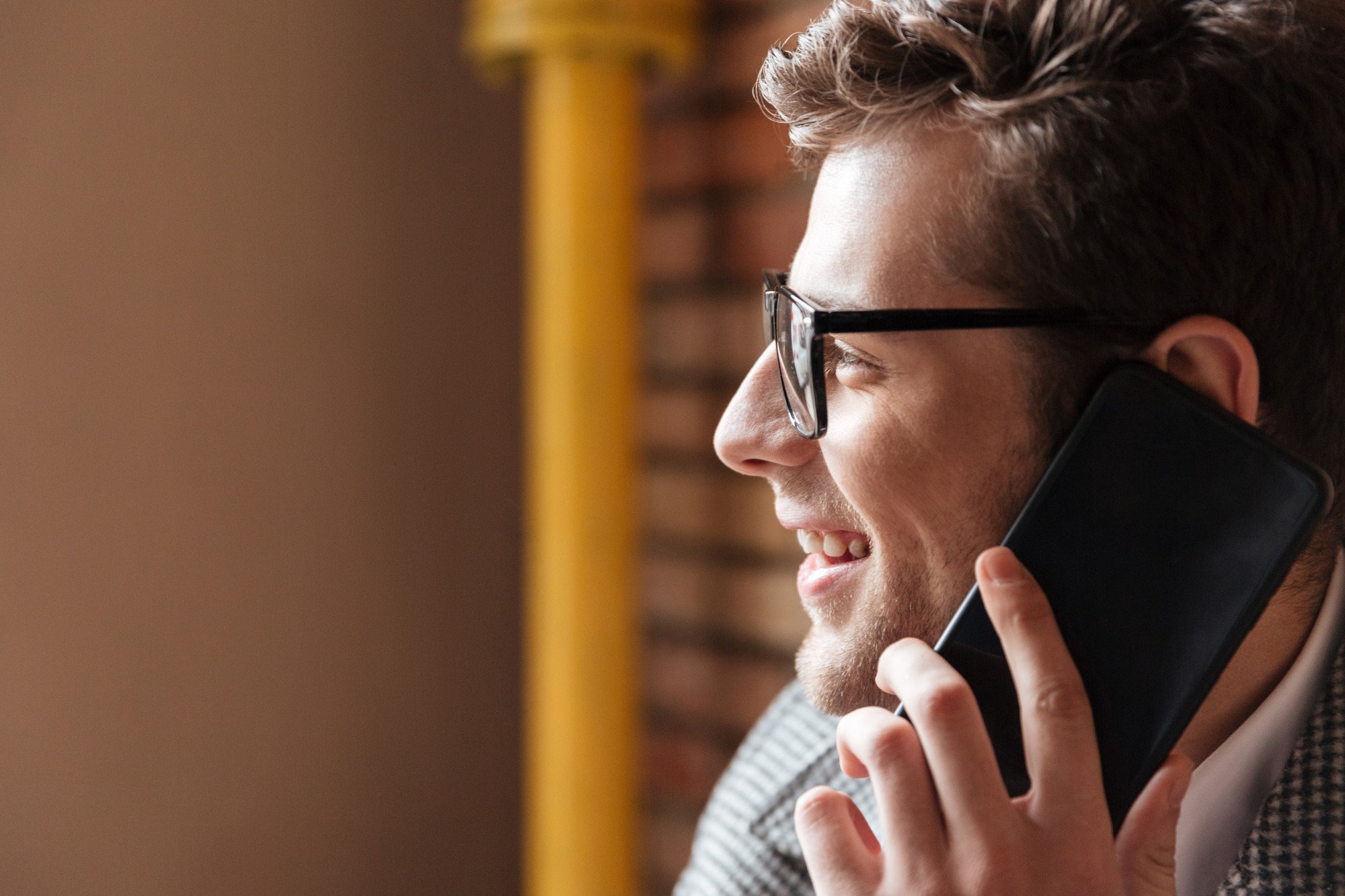 A man smiling while on a call | Source: Freepik