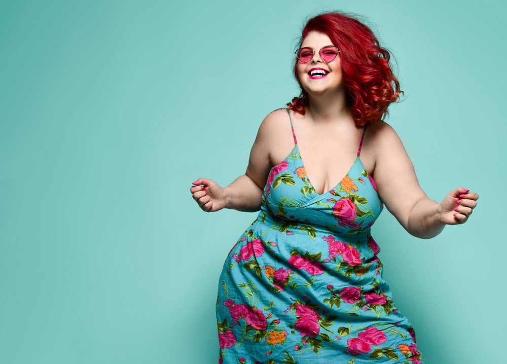 Chica pelirroja de talla grande luciendo un vestido de flores. I Foto: Shutterstock.
