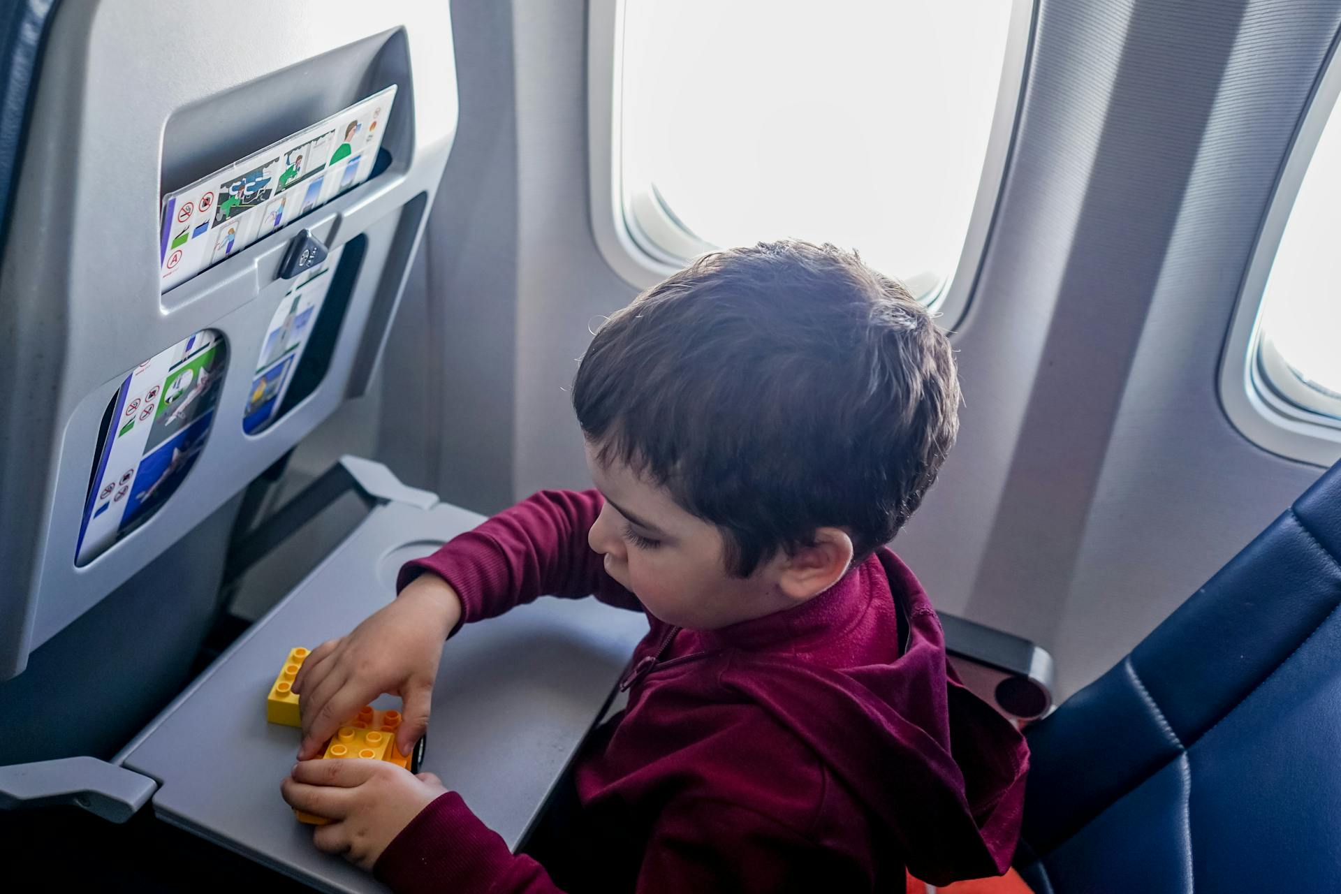 A boy playing with his toys during a flight | Source: Pexels