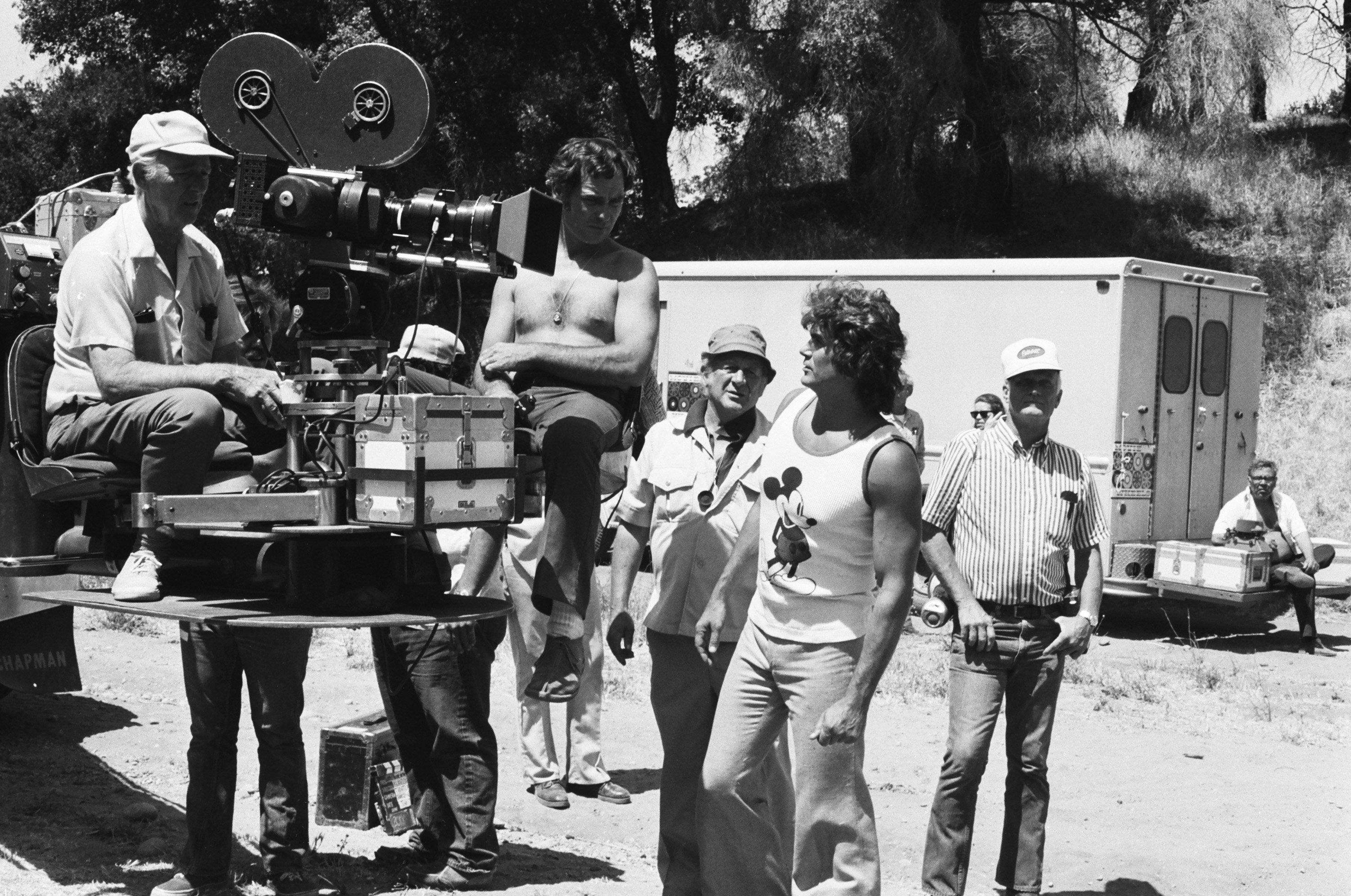 Pictured: Director Michael Landon in a white undershirt photographed with crew members on the set of " Little House on the Prairie," on December 10, 1975. | Source: Getty Images