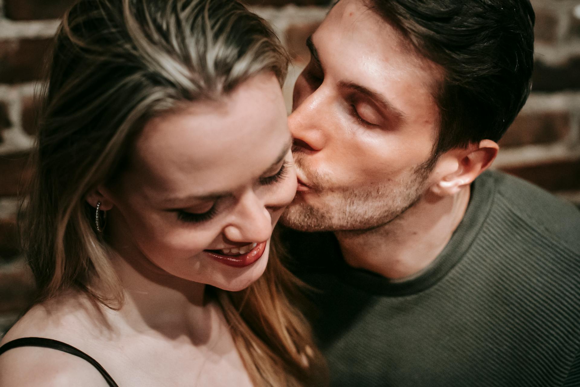A man kissing his girlfriend on the cheek | Source: Pexels