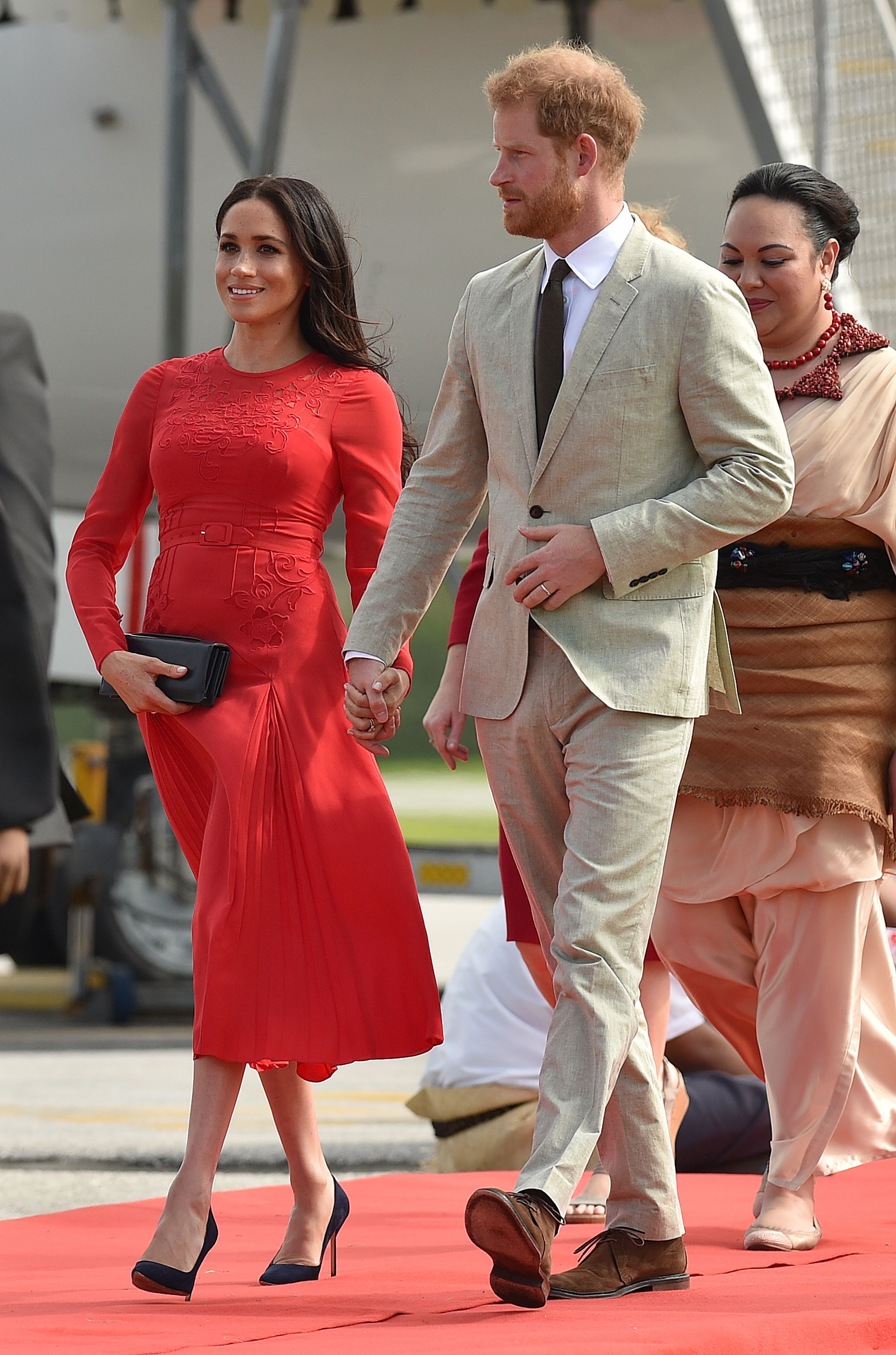 Britain's Prince Harry and his wife Meghan, Duchess of Sussex arrive at Fua'amotu airport in Tonga on October 25, 2018 | Source: Getty Images