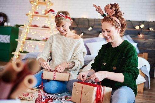 Sisters Opening Christmas Presents While Sitting At Home | Photo: Getty Images