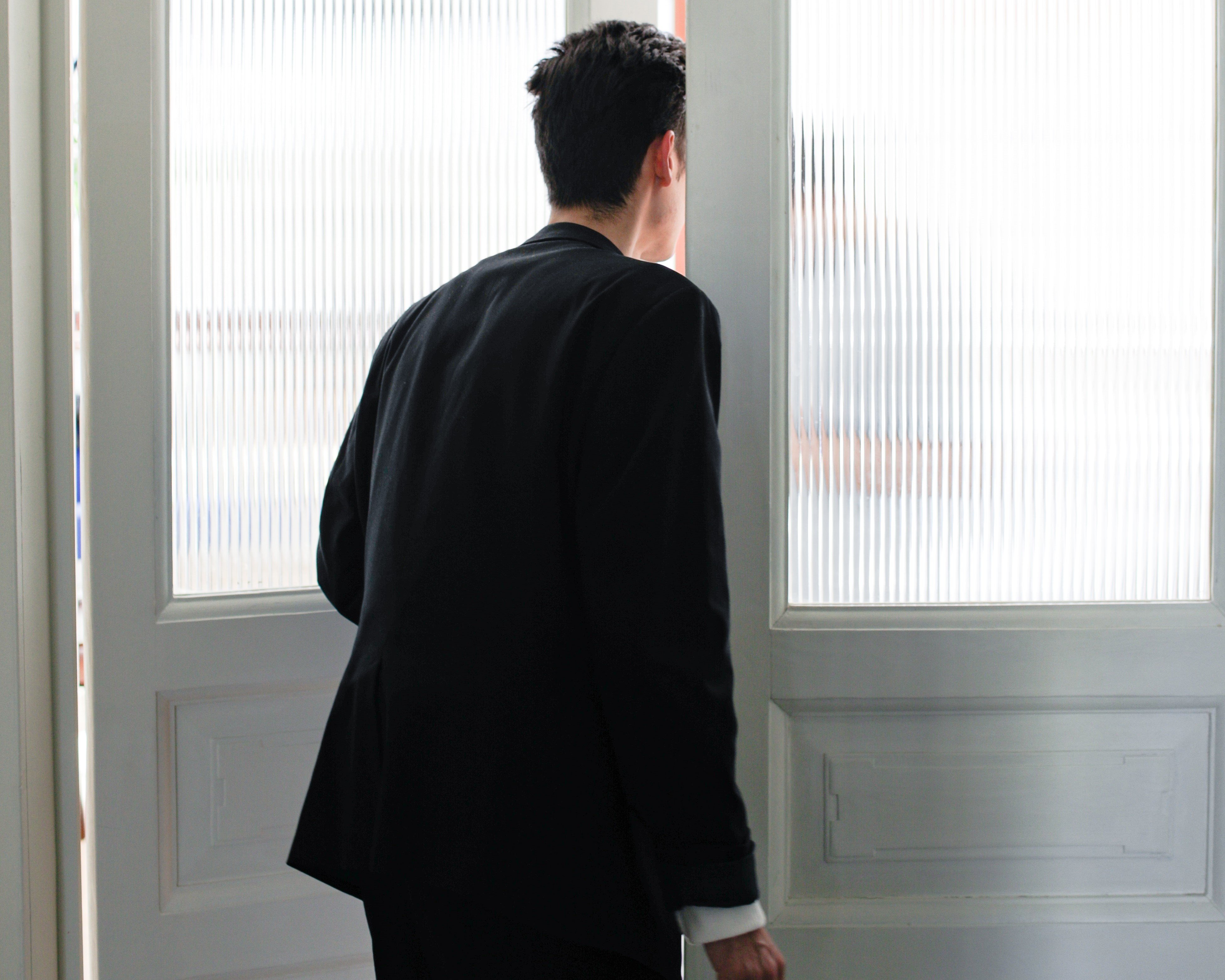 Un hombre asomado en una puerta. | Foto: Pexels