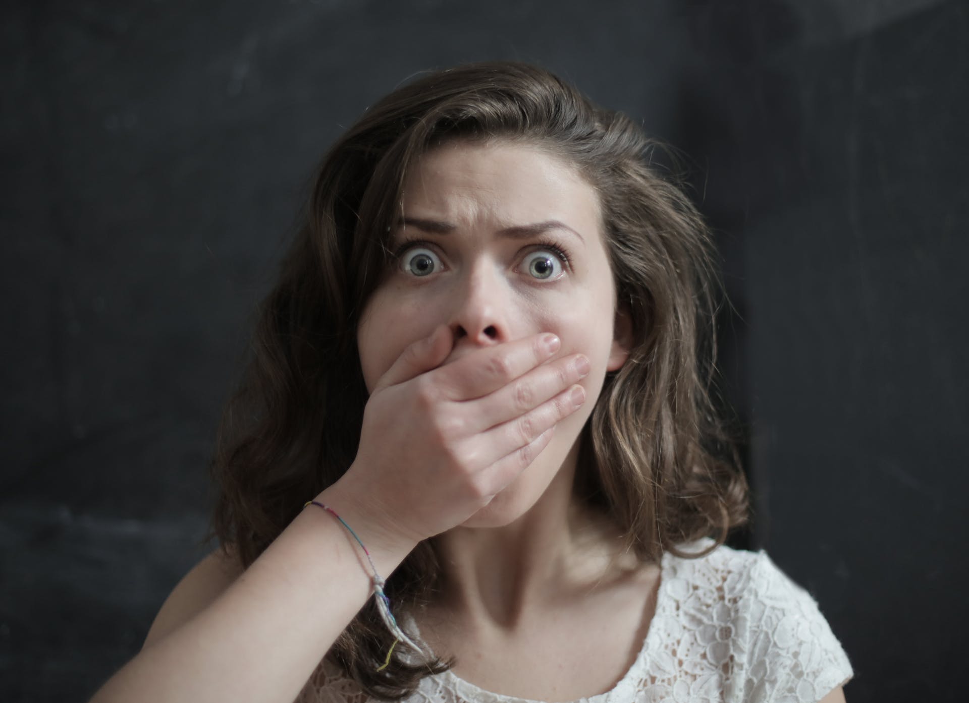 A shocked woman covering her mouth with her hand | Source: Pexels
