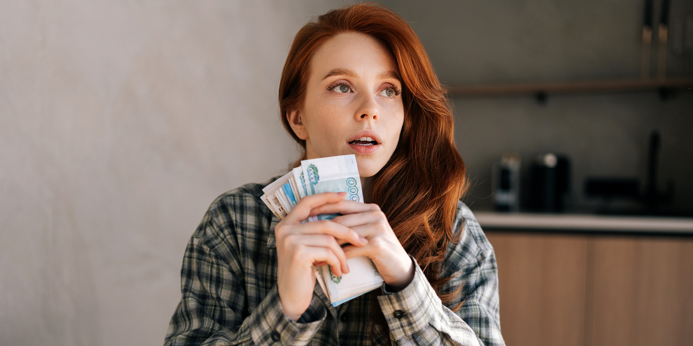 A woman holding money bills | Source: Shutterstock