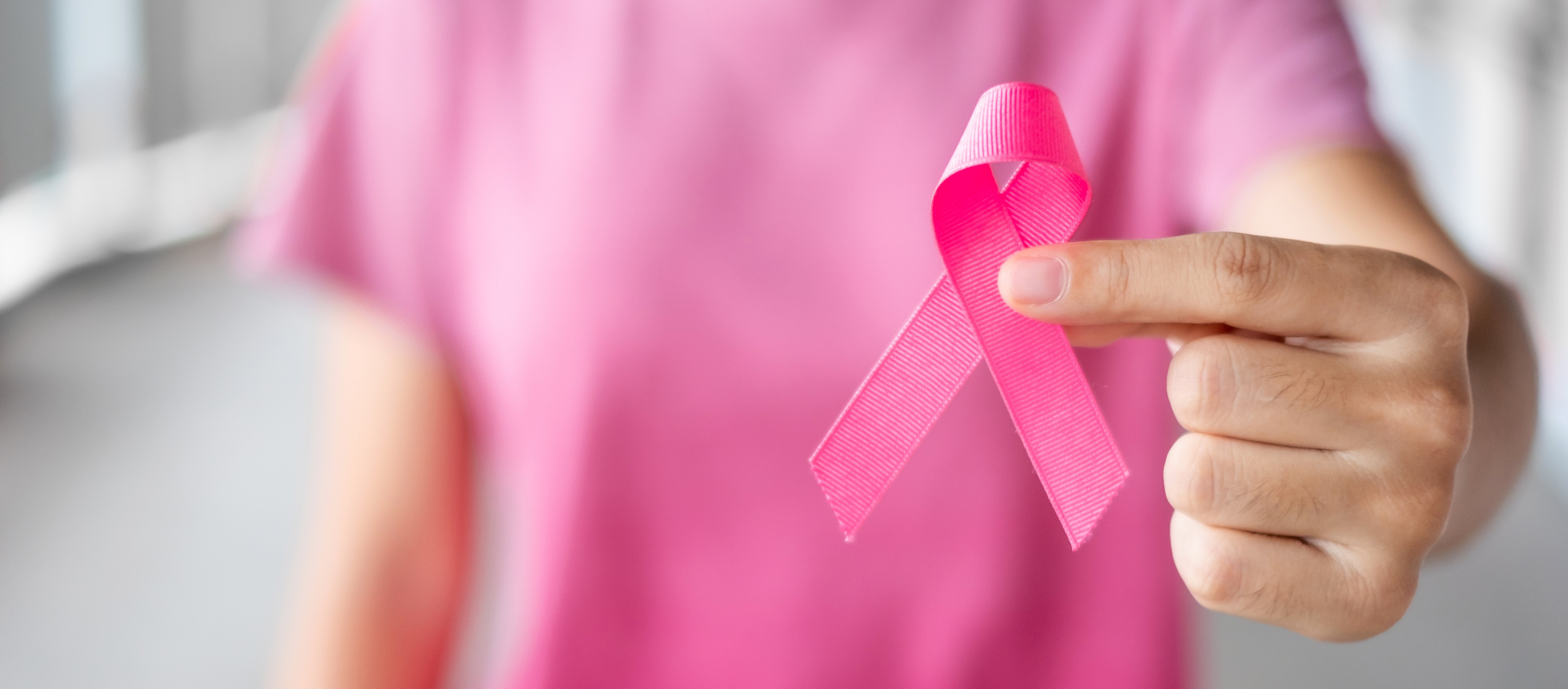 Mujer con camiseta rosa sostiene lazo rosa contra el cáncer de mama. | Foto: Shutterstock