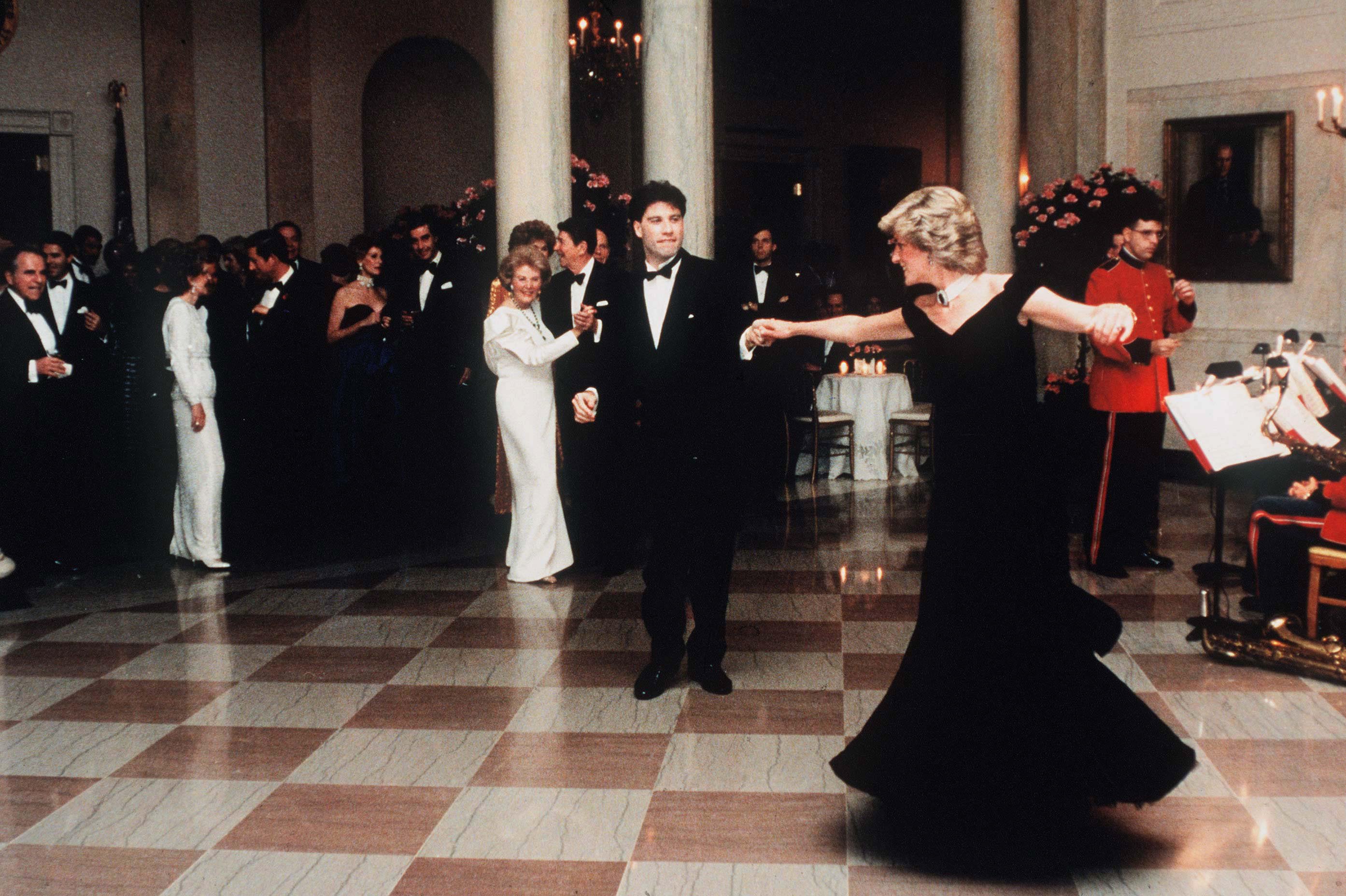 Diana, Princess Of Wales, watched by President Ronald Reagan and wife Nancy, dances with John Travolta at the White House, USA on November 9, 1985. | Photo: Getty Images