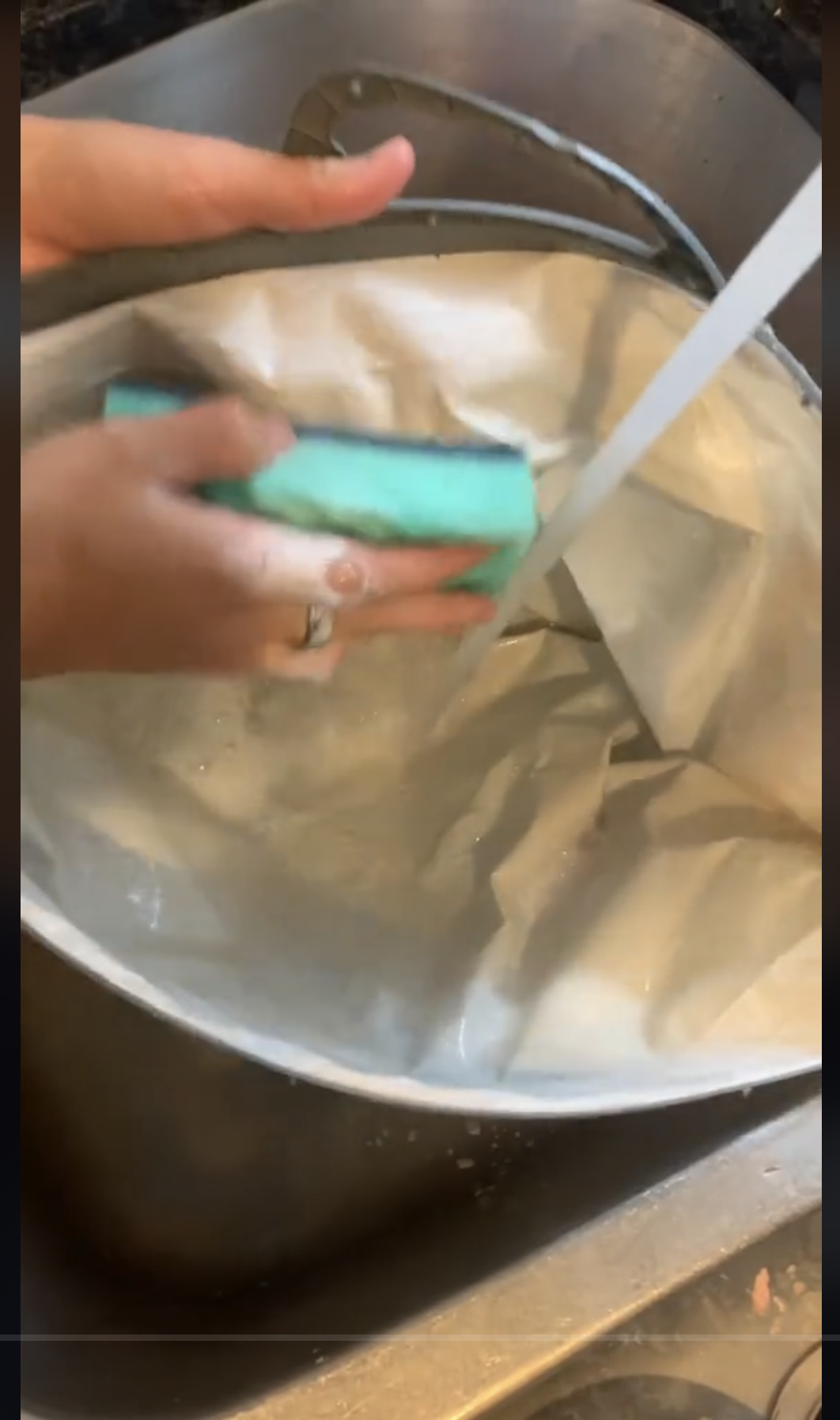 A person washing a reusable grocery bag with soapy water, as seen in a video dated September 22, 2023 | Source: TikTok/@consumerreports