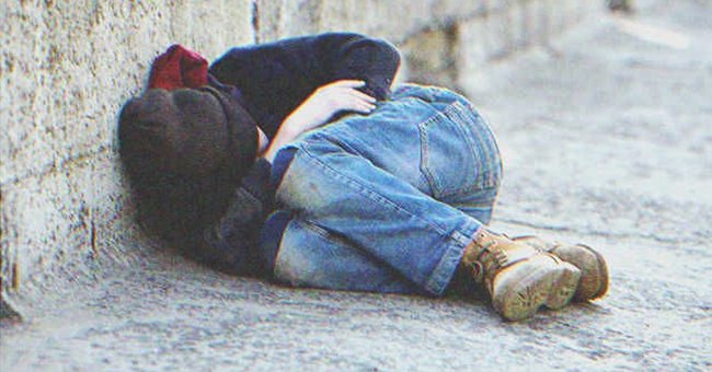 A homeless boy laying on the street | Source: Shutterstock