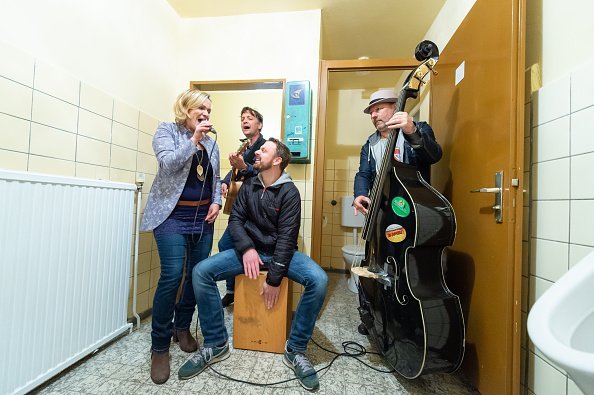 A music band pictured having fun in the restroom | Photo: Getty Images