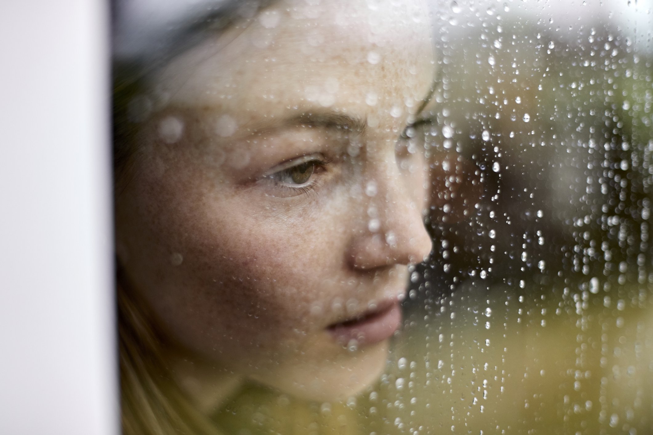 Unhappy young lady looking out the window. | Photo: Getty Images