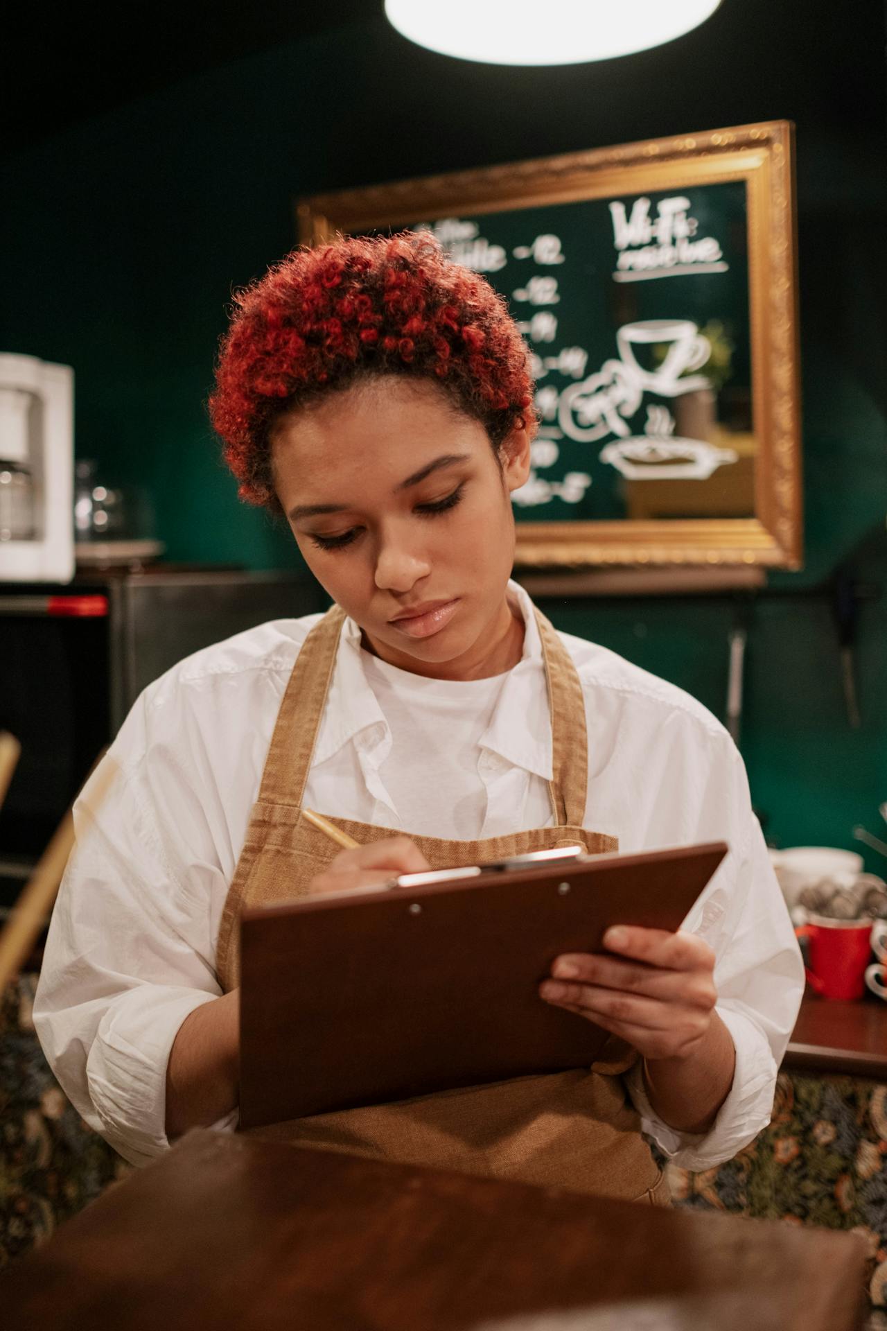 A woman in an apron taking an order in an eatery | Source: Pexels