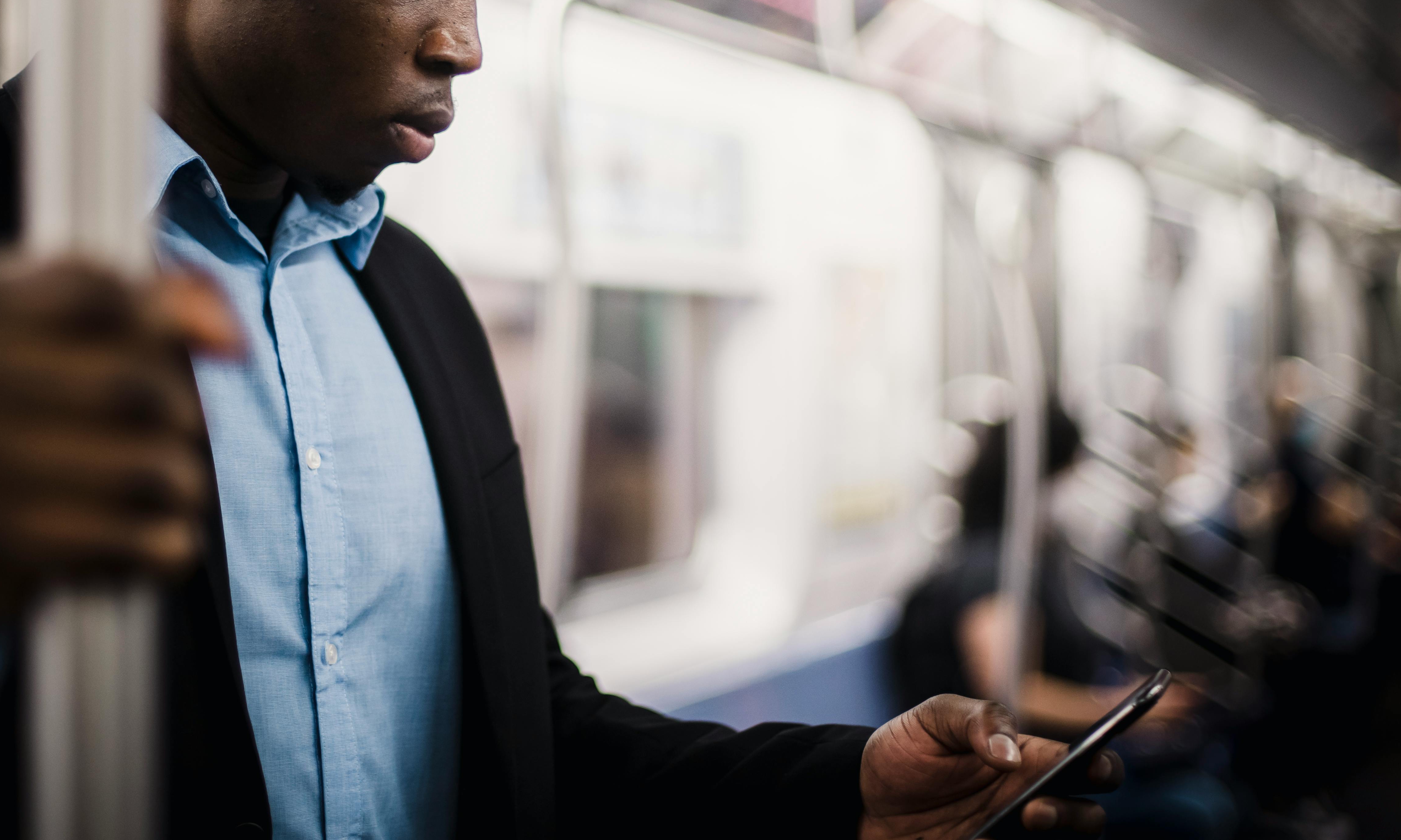 A man works his cell phone on a subway carriage | Source: Pexels