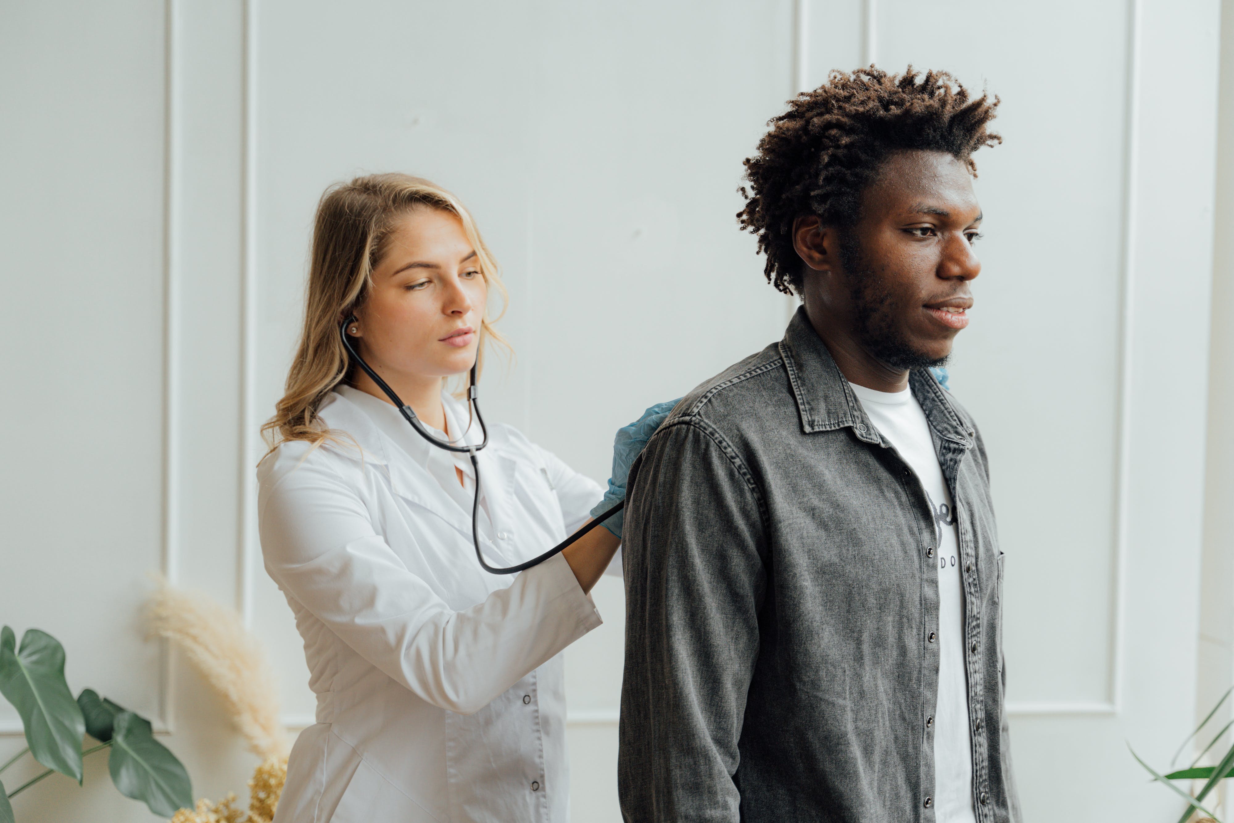 A female doctor checking a man's back. | Source: Pexels