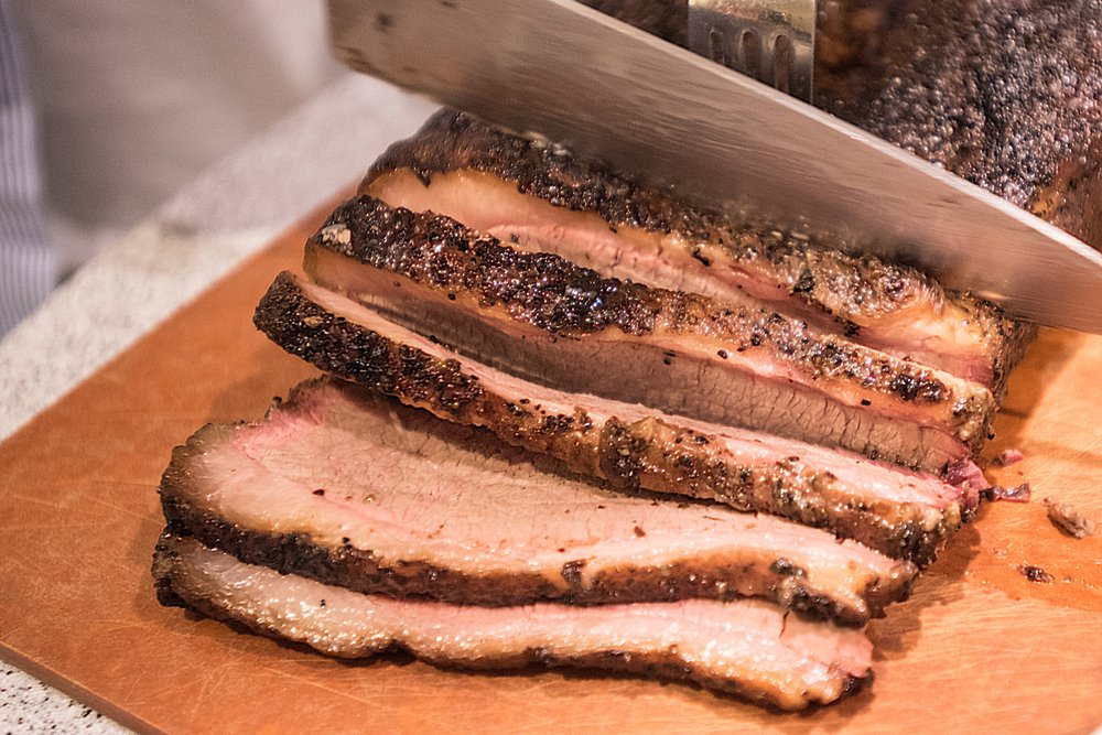 Poitrine de boeuf de barbecue étant coupé sur une planche à découper. | Shutterstock