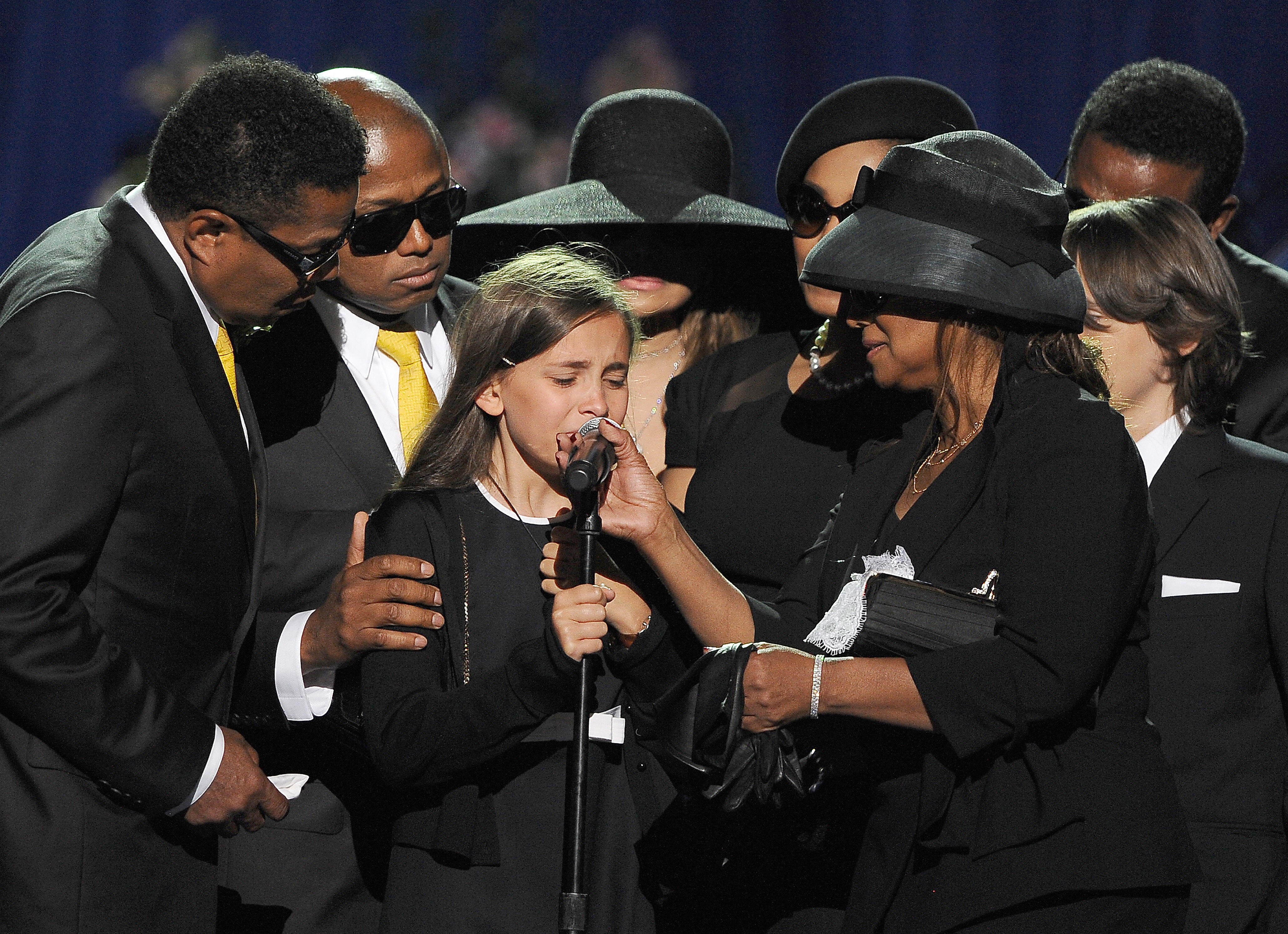 Paris Michael Katherine Jackson (C) is comforted by the brothers and sisters of Michael Jackson including Marlon (L) and Randy (2nd L) Jackson at the memorial service for the King of Pop at the Staples Center in Los Angeles on July 7, 2009 | Source: Getty Images 
