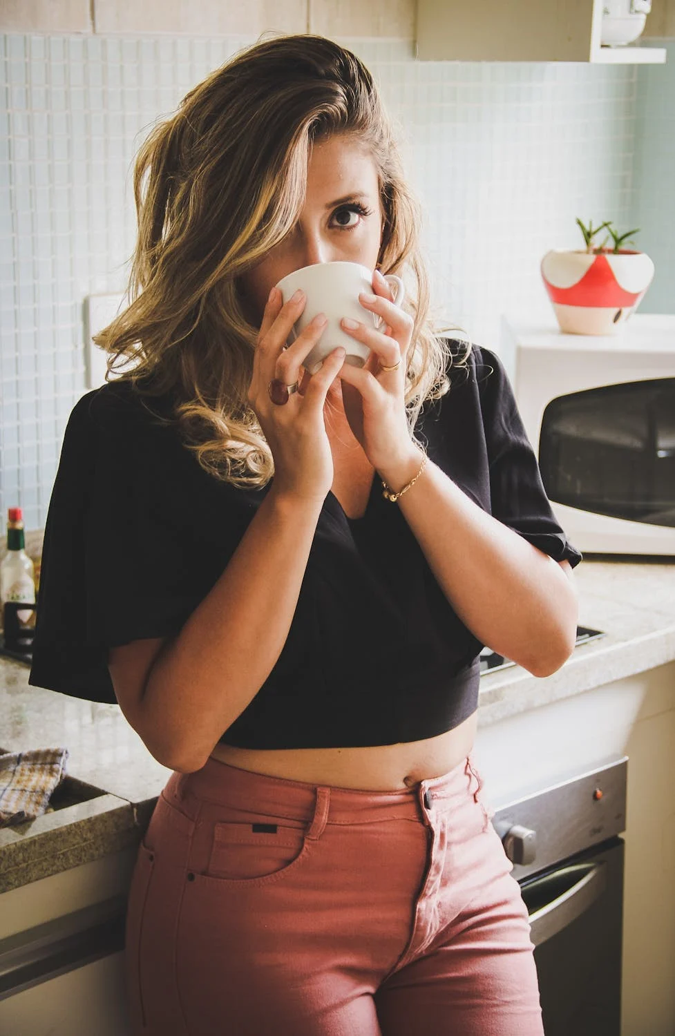 Een vrouw die thee drinkt in haar keuken | Bron: Pexels