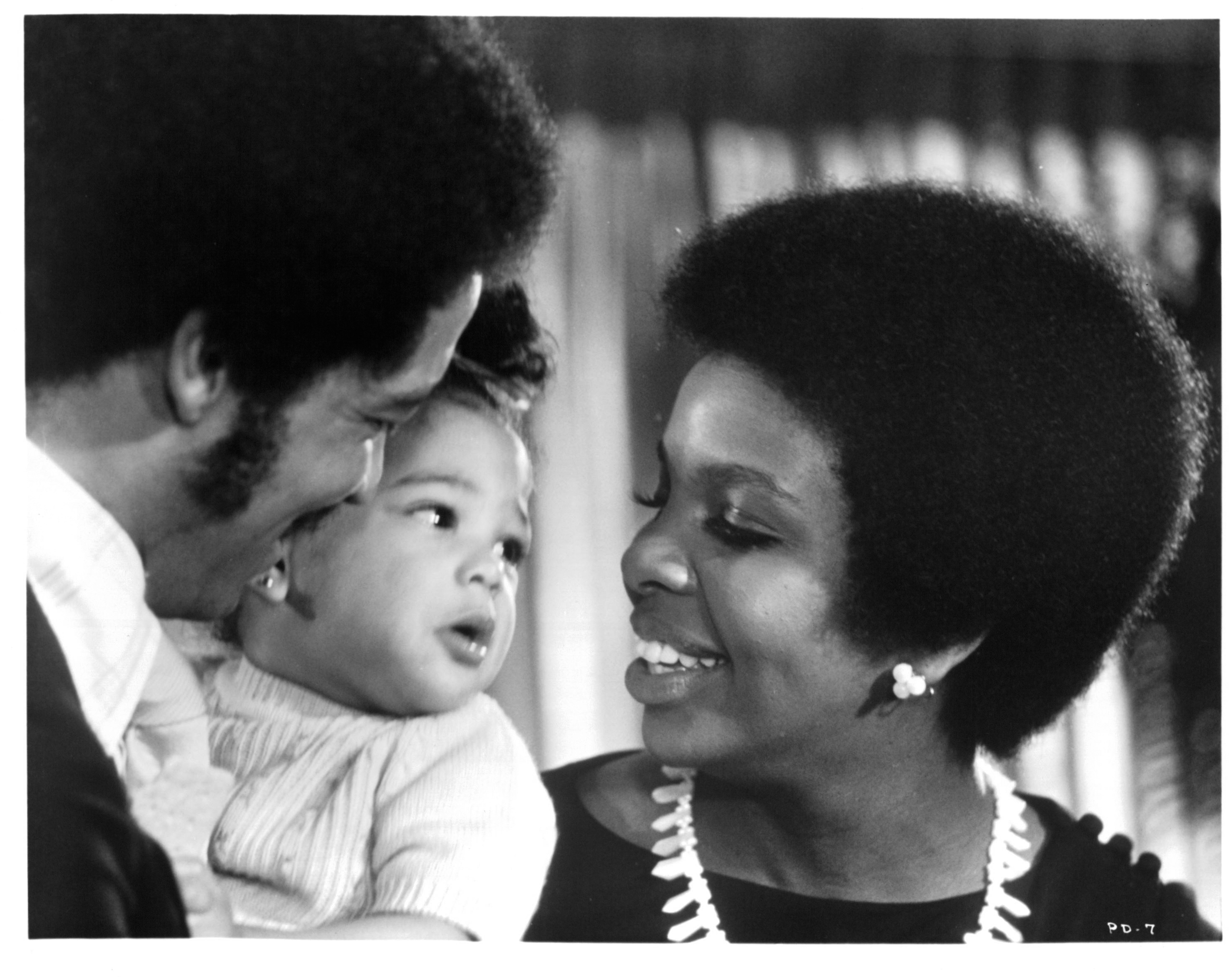 Barry Hankerson and Gladys Knight with a baby in a scene from the film "Pipe Dreams," in 1976. | Source: Getty Images