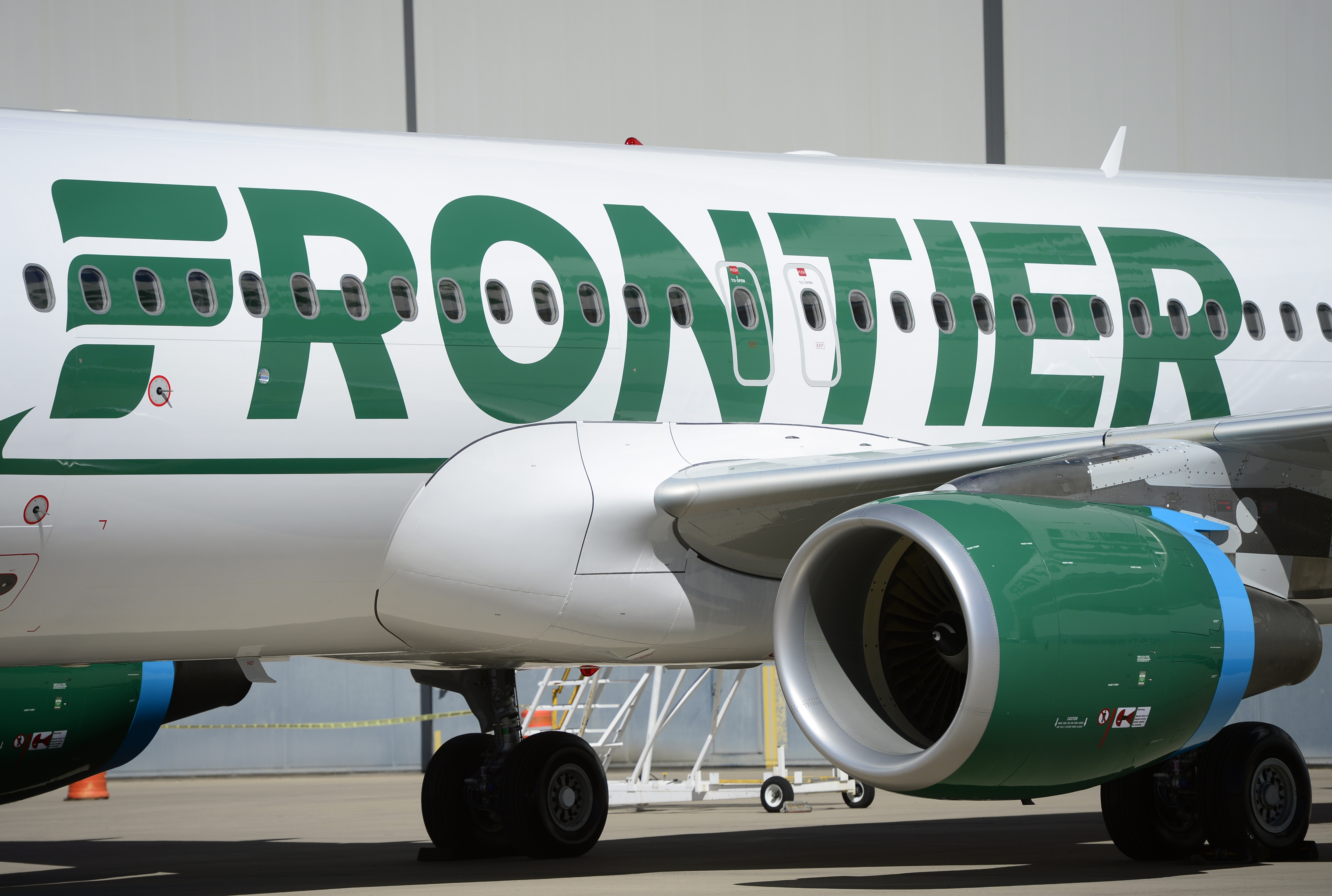A closer look at a Frontier Airlines aircraft parked outside a hangar | Source: Getty Images